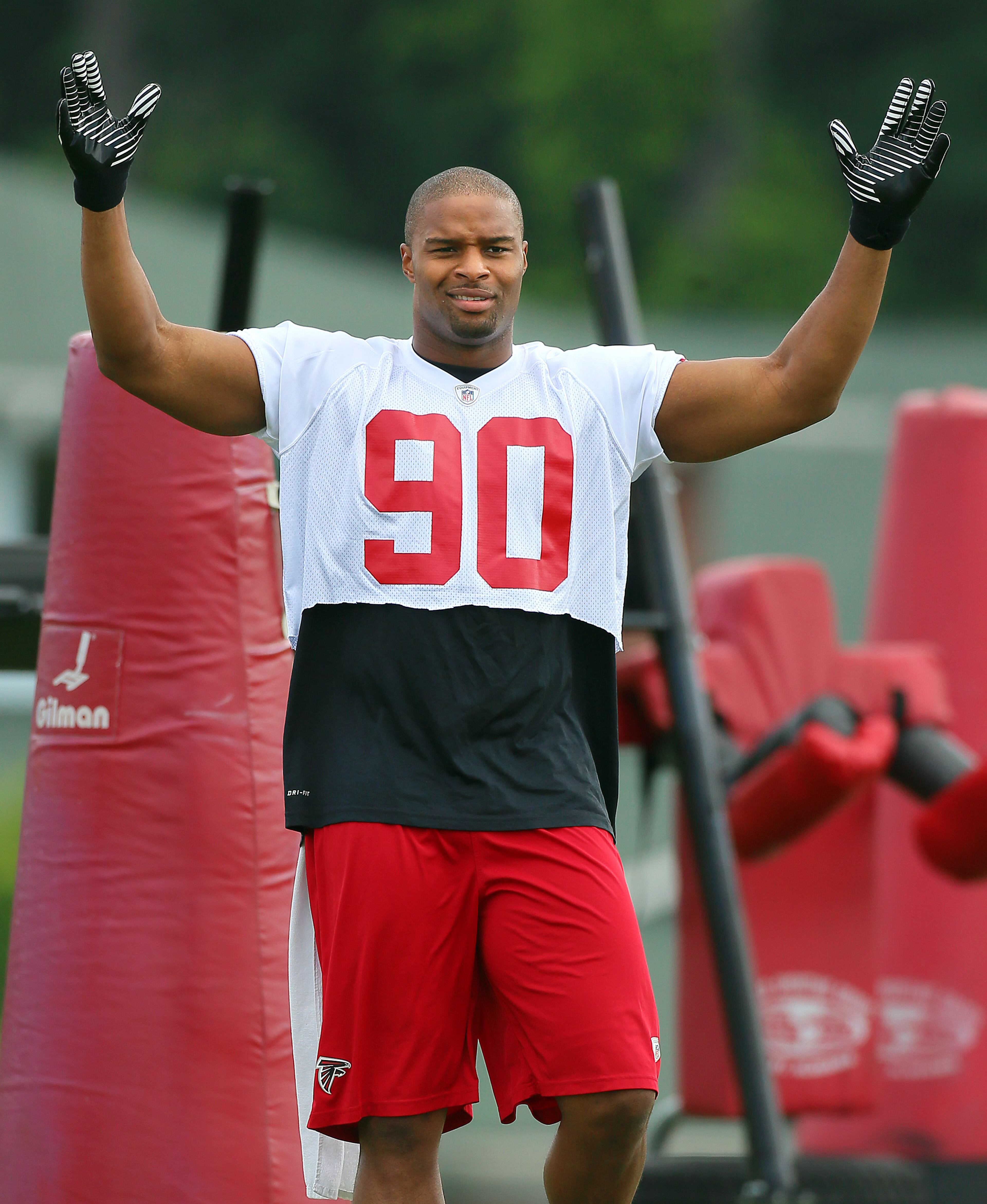 Falcons defensive end Osi Umenyiora accepts the cheers of his teammates after a drill during team practice on Wednesday, May 29, 2013, in Flowery Branch. Umenyiora is being counted on to stabalize the defensive line and be a pass rusher. CURTIS COMPTON / CCOMPTON@AJC.COM