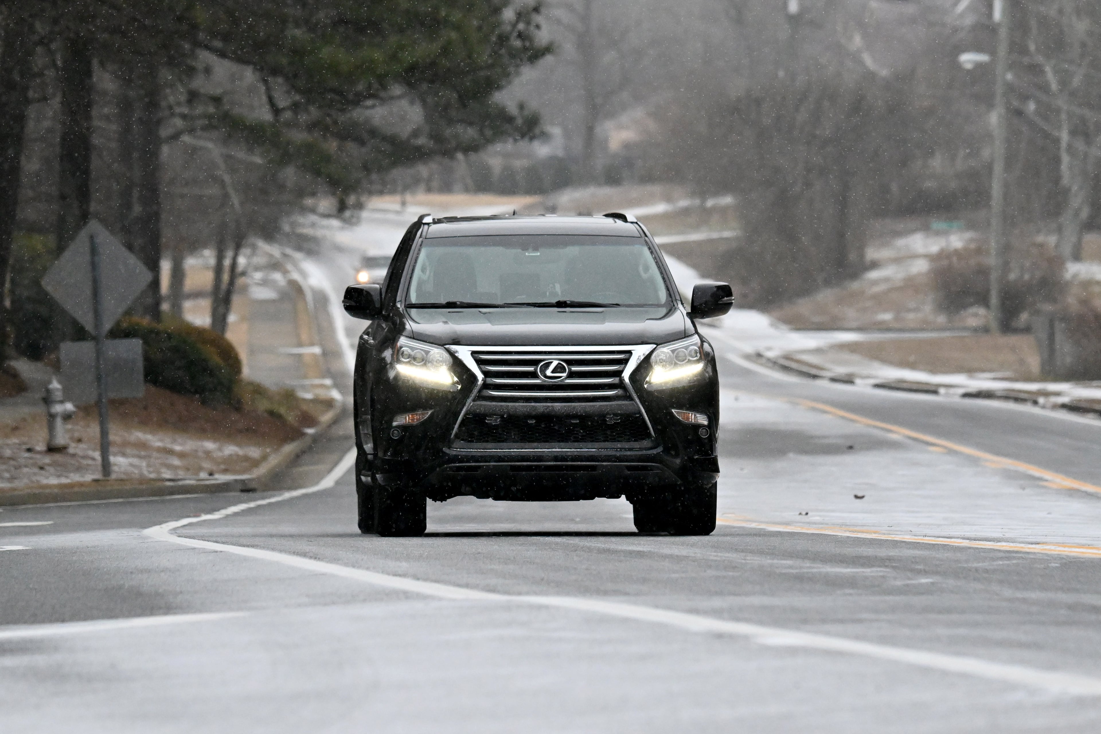 A car travels along as light snow falls in Snellville on Saturday, Jan. 31, 2026. Snow has been steadily turning parts of Middle and North Georgia, including metro Atlanta, into a snow globe. (Hyosub Shin/AJC)