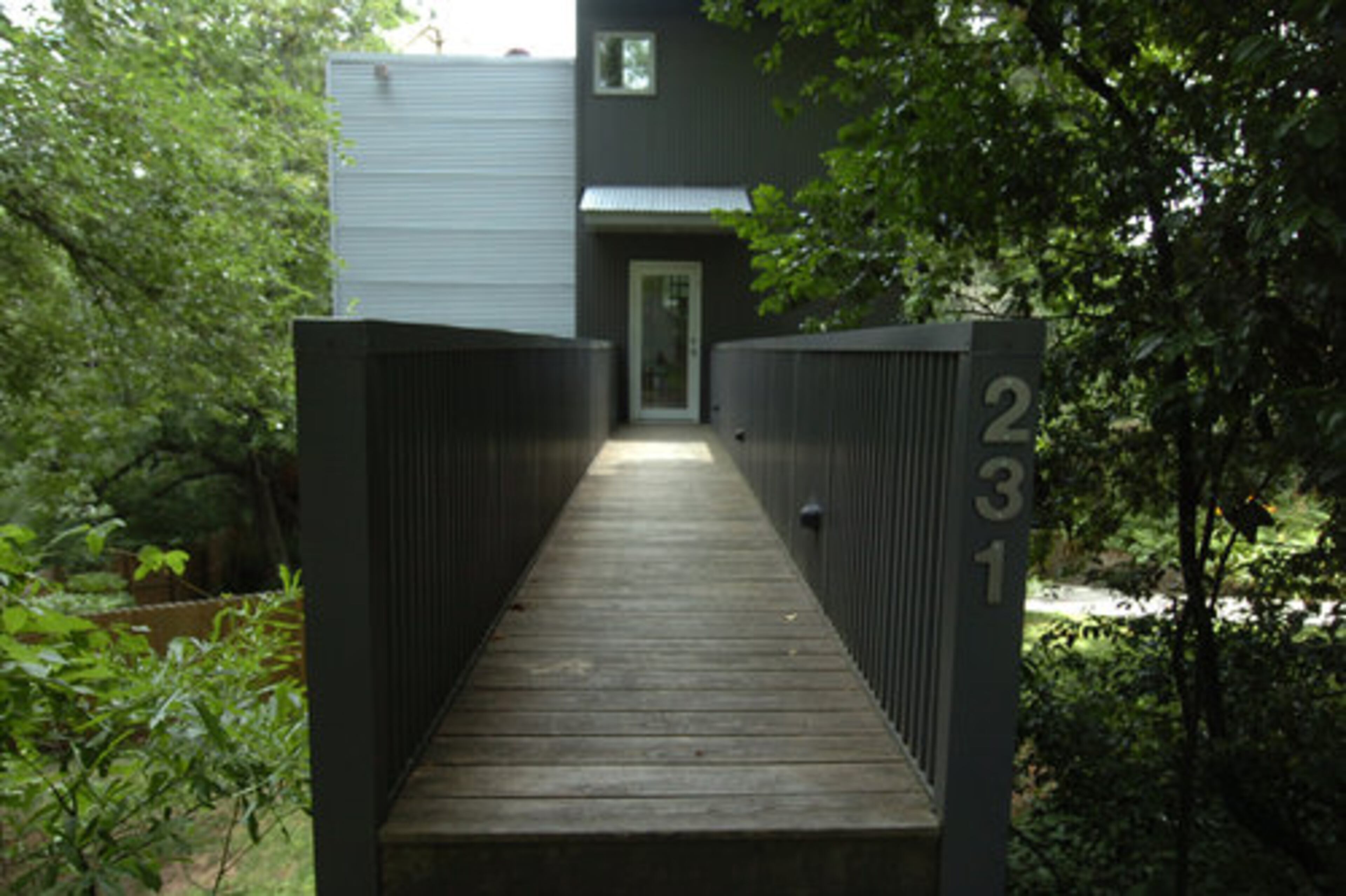 To enter the home, the owners must cross a bridge over the sharply sloping lot.