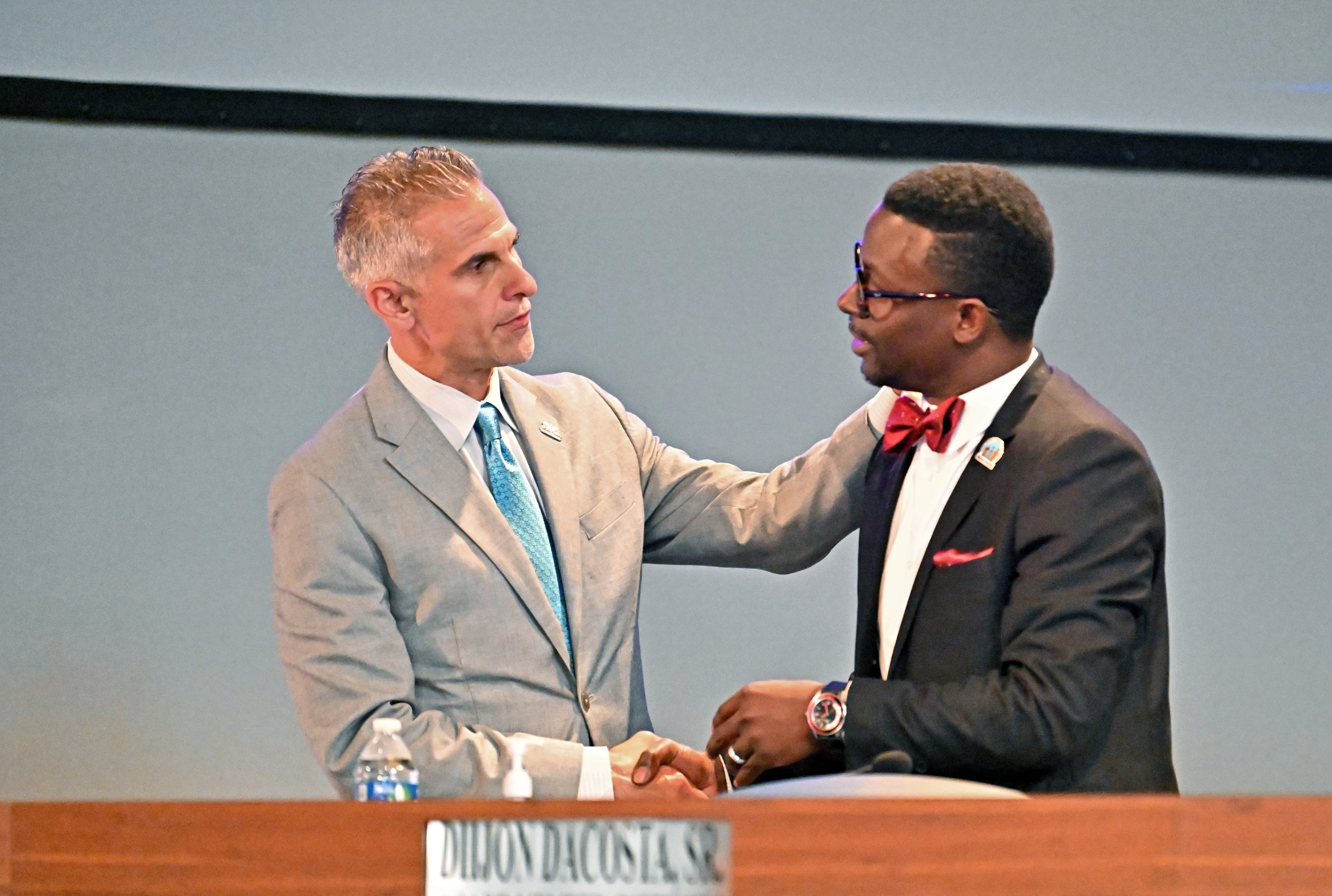 DeKalb school acting superintendent Norman Sauce III (left) talks to board member Diijon DaCosta Sr. before board members vote Wednesday, October 15, 2025. (Hyosub Shin / AJC)