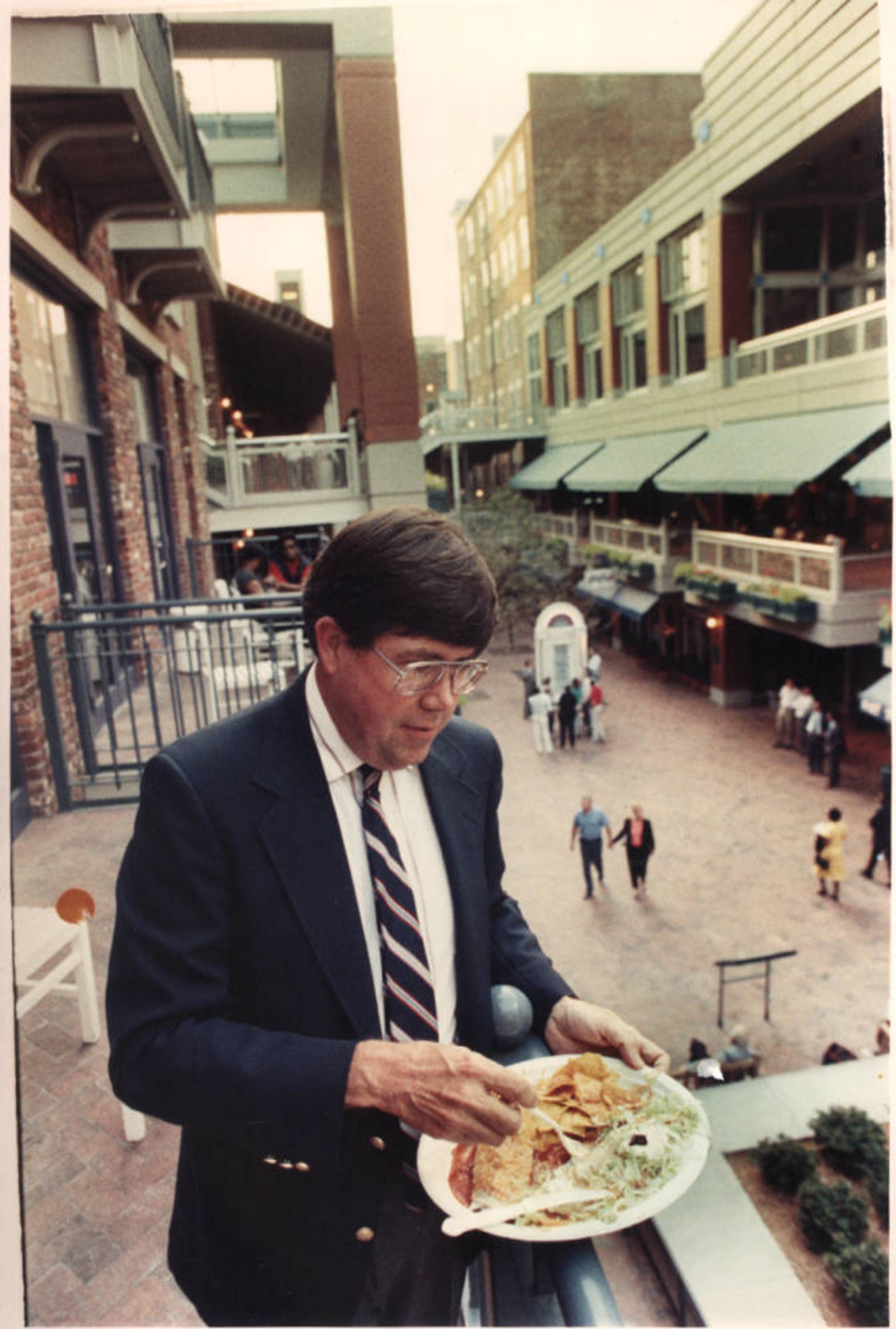 Man eating tacos on upper floor of Underground Atlanta, Atlanta, Georgia, 1980s.