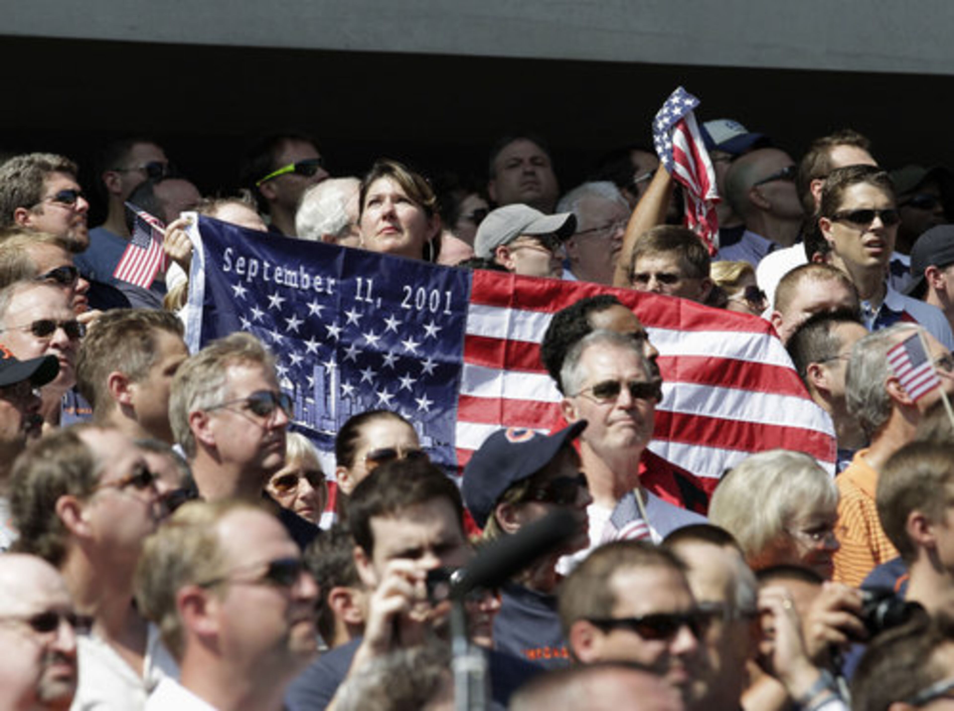 Fans hold a commemorative flag at Soldier Field before an NFL football game between the Chicago Bears and the Atlanta Falcons in Chicago, Sunday, Sept. 11, 2011. The day marks the 10th anniversary of the Sept. 11 terrorist attacks.