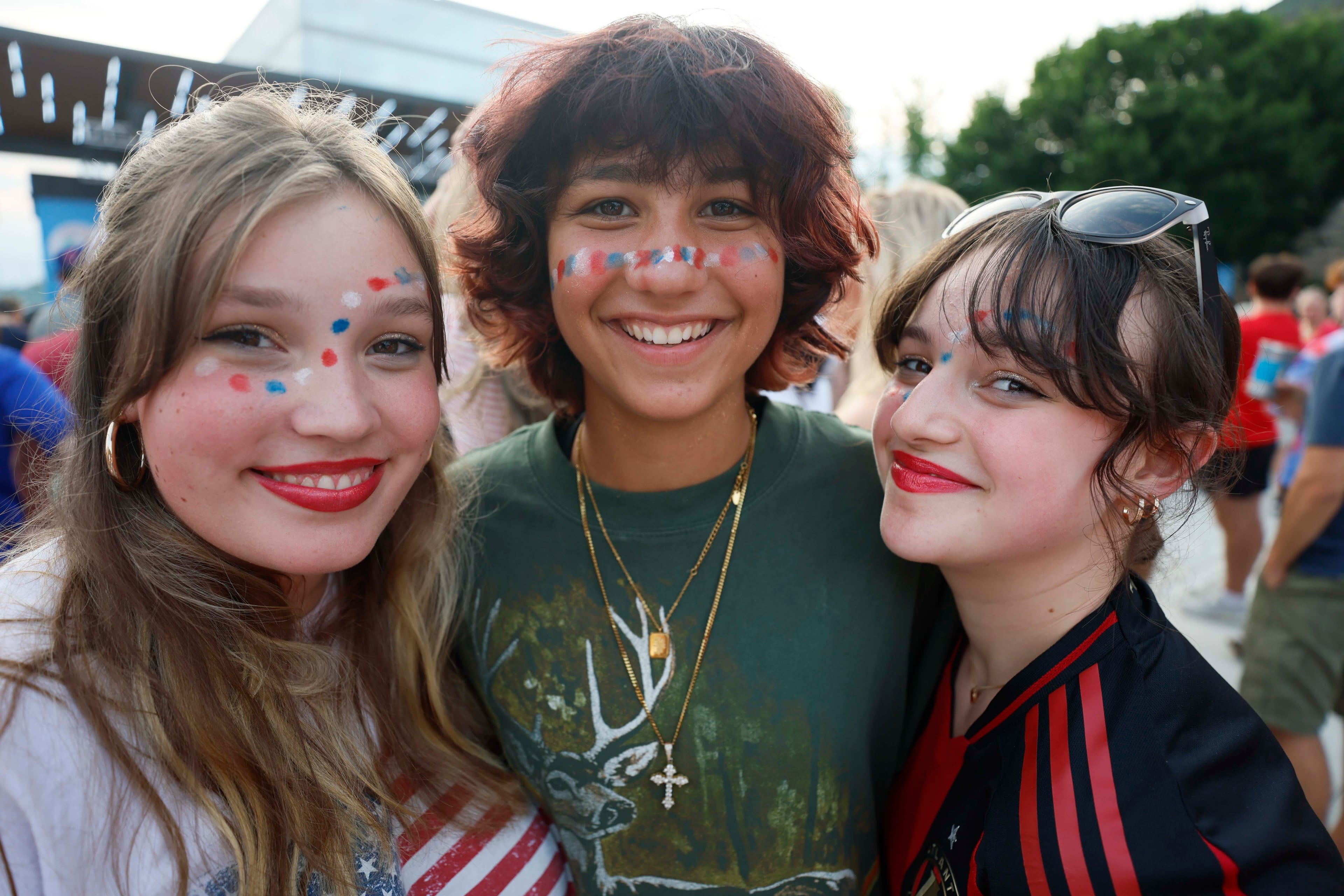 Olivia Sipe (from left), 15, Alex Graham, 15, and Haddie Singletary, 14, of Decatur pose for a pic as they listen to the War and Treaty concert before watching the USA World Cup game at Decatur WatchFest ’26 on Thursday, June 25, 2026. (Miguel Martinez/AJC)