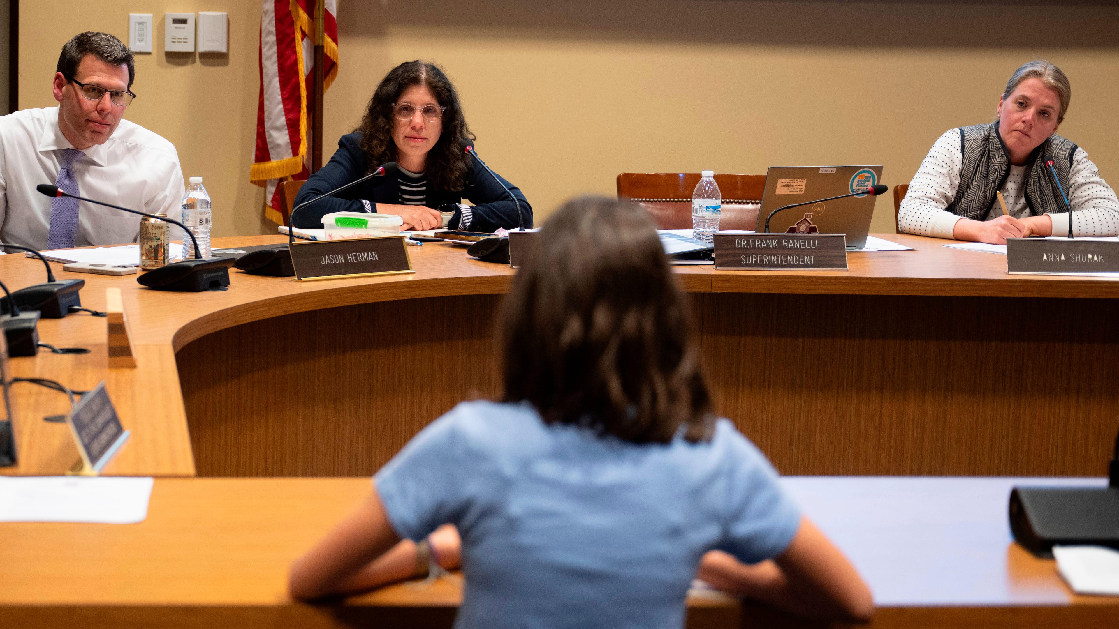 Members of the Lower Merion Board of School Directors speak with a student at a school board meeting on Monday, May 11, 2026, in Ardmore, Pa. (AP Photo/Joe Lamberti)