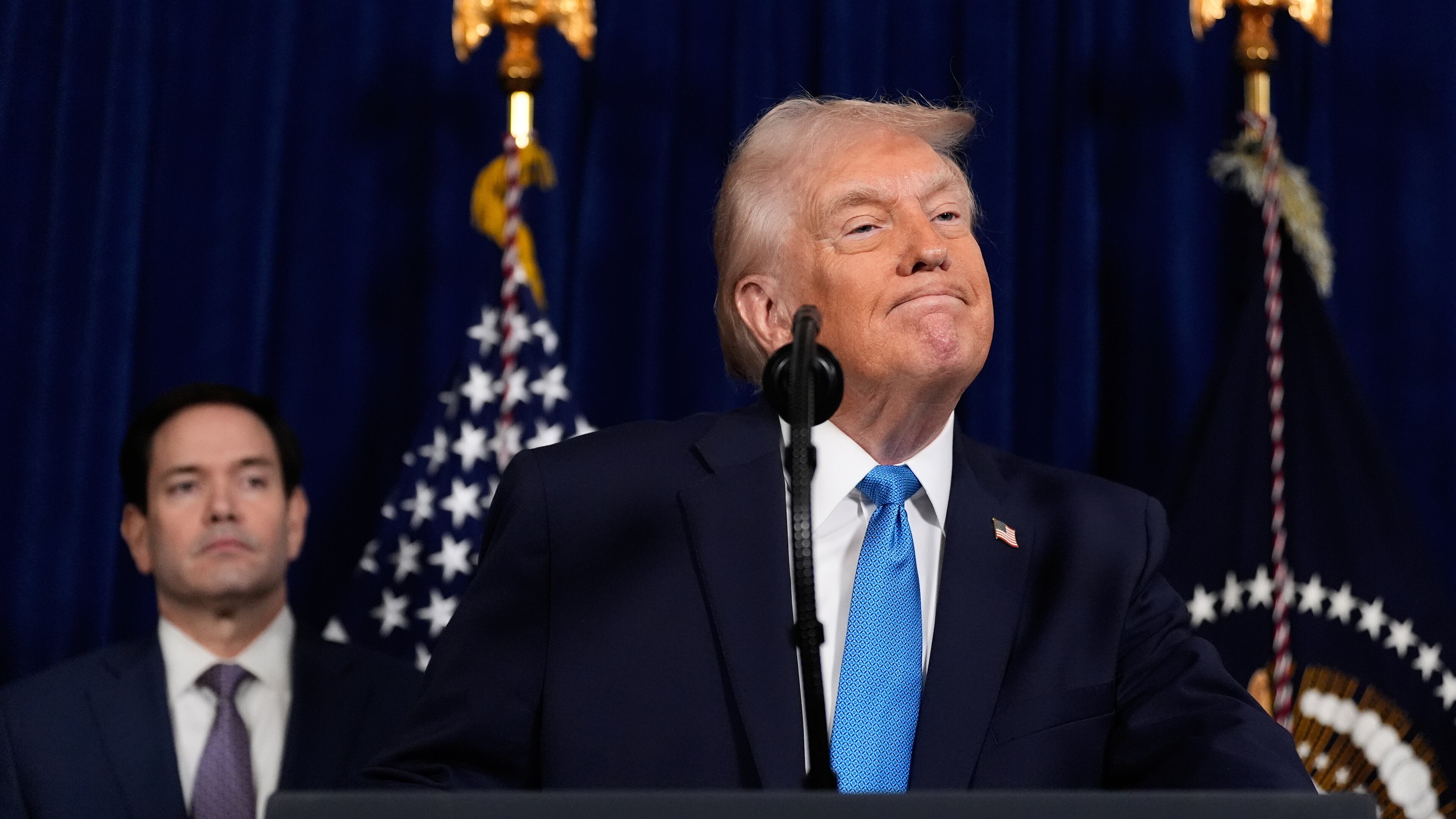 President Donald Trump listens to a question during a news conference at Mar-a-Lago, Saturday, Jan. 3, 2026, in Palm Beach, Fla., as Secretary of State Marco Rubio watches. (AP Photo/Alex Brandon)