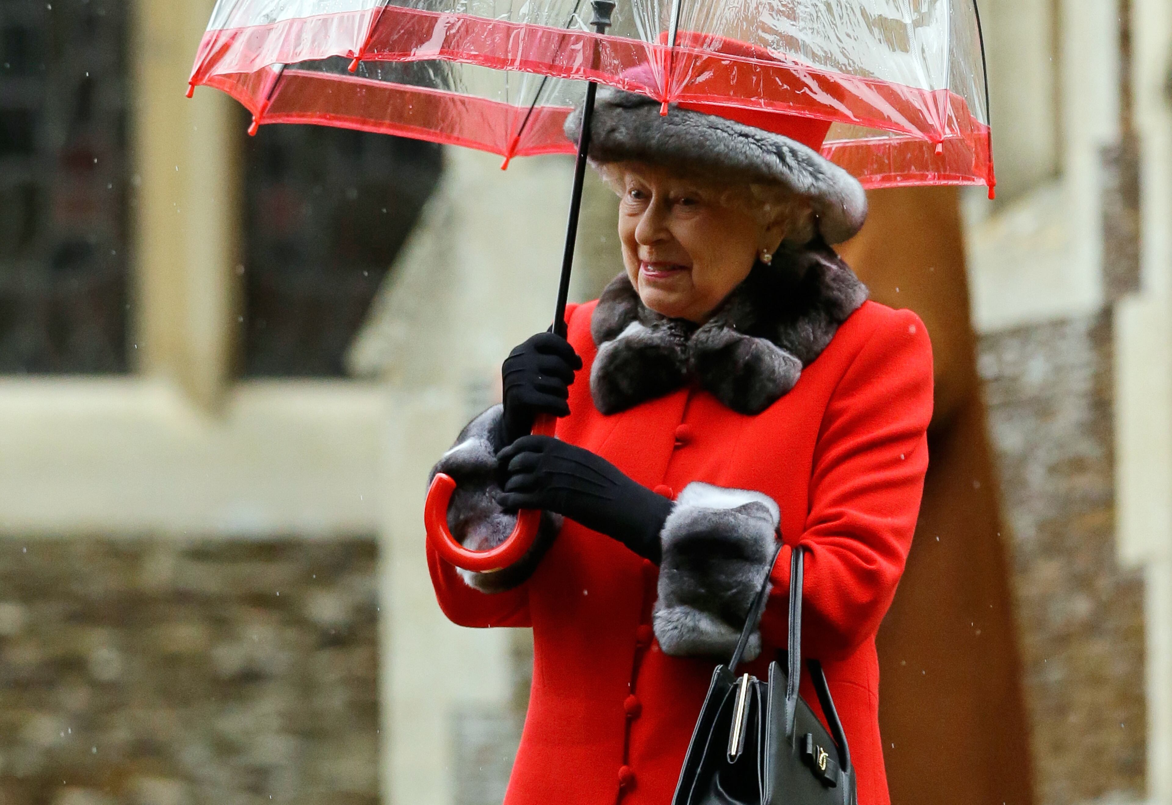 Britain's Queen Elizabeth II shelters under an umbrella as she leaves, after attending the British royal family's traditional Christmas Day church service at St. Mary Magdalene Church in Sandringham, England, Friday, Dec. 25, 2015. (AP Photo/Matt Dunham)