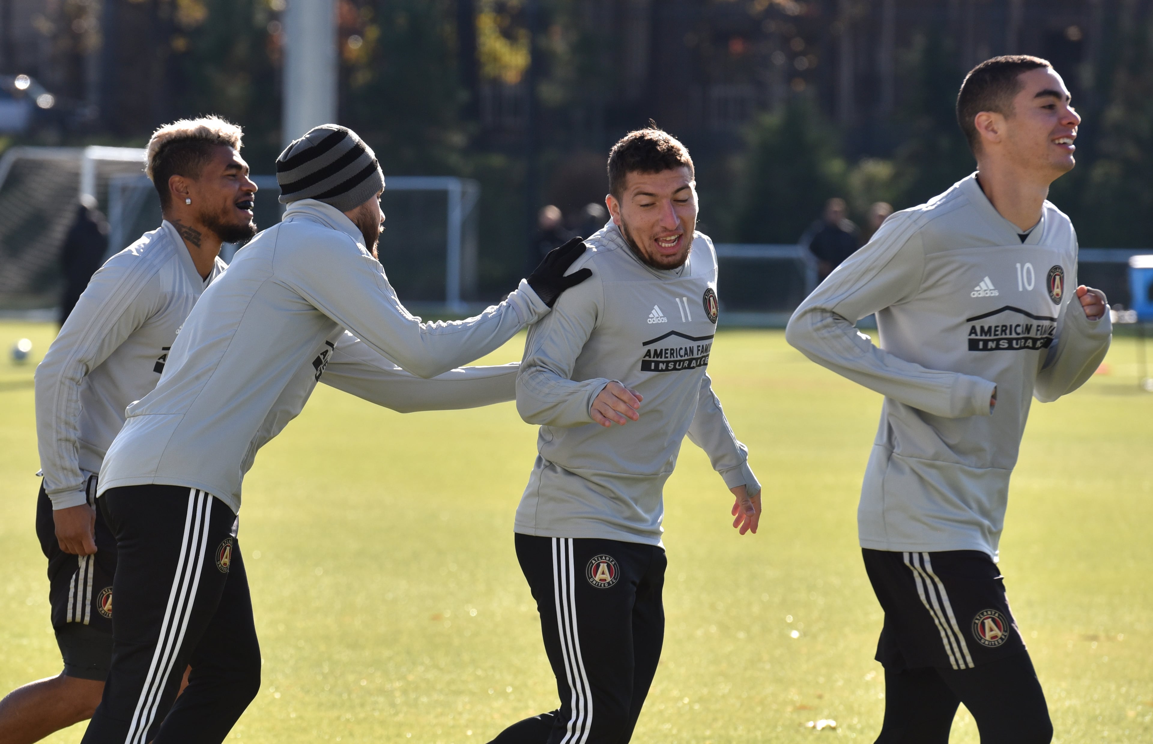 Defender Jose Hernandez (13) and midfielder Eric Remedi (11) joke around as they warm up during Tuesday's practice at Children's Healthcare of Atlanta Training Ground in Marietta. (Hyosub Shin/hshin@ajc.com)