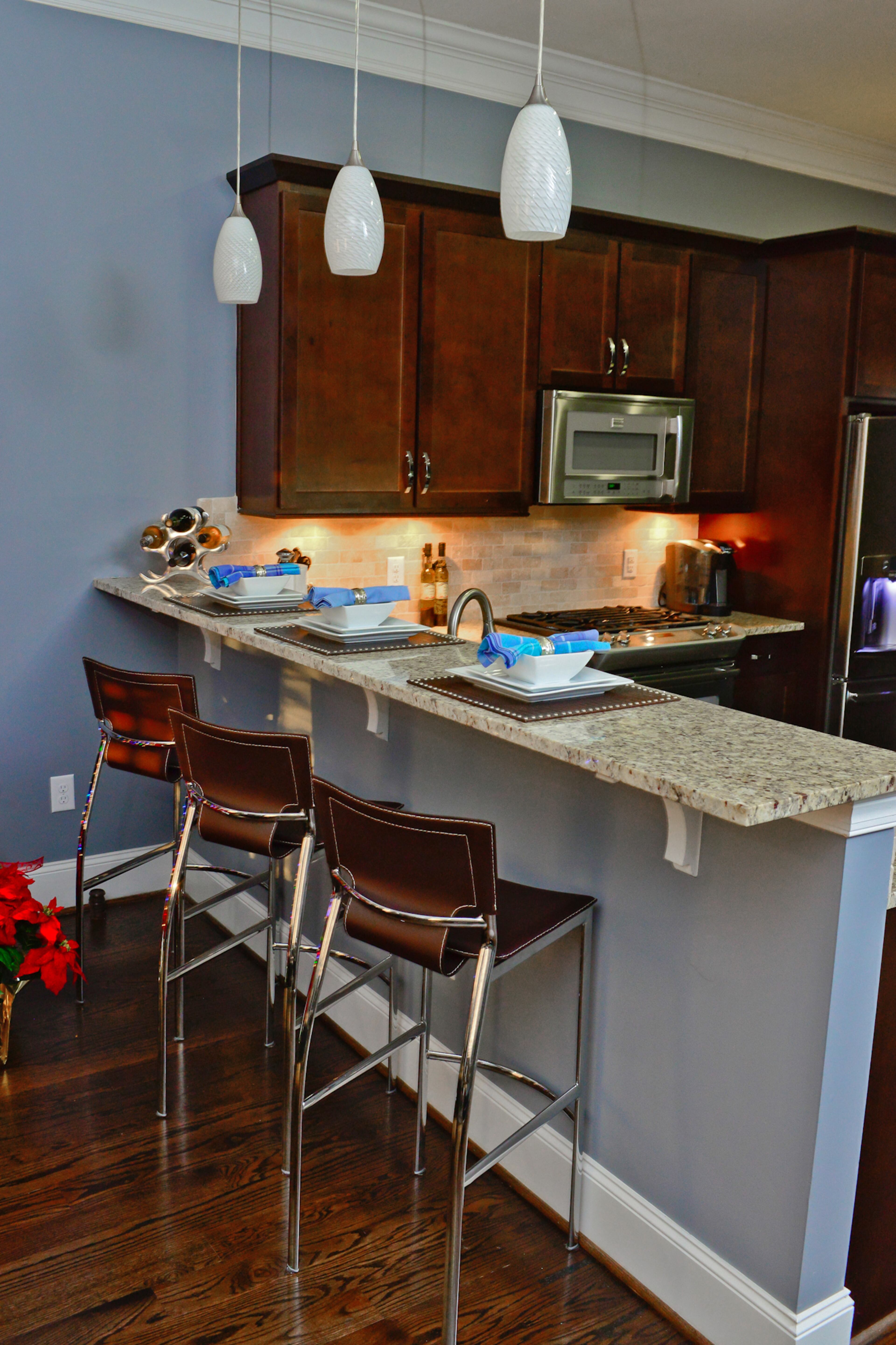 The townhome's kitchen was already up to date with granite countertops, tile backsplash and dark cabinets. Larry Brown added Frigidaire and GE Appliances from Appliance Smart, and bought the bar stools from By Design.