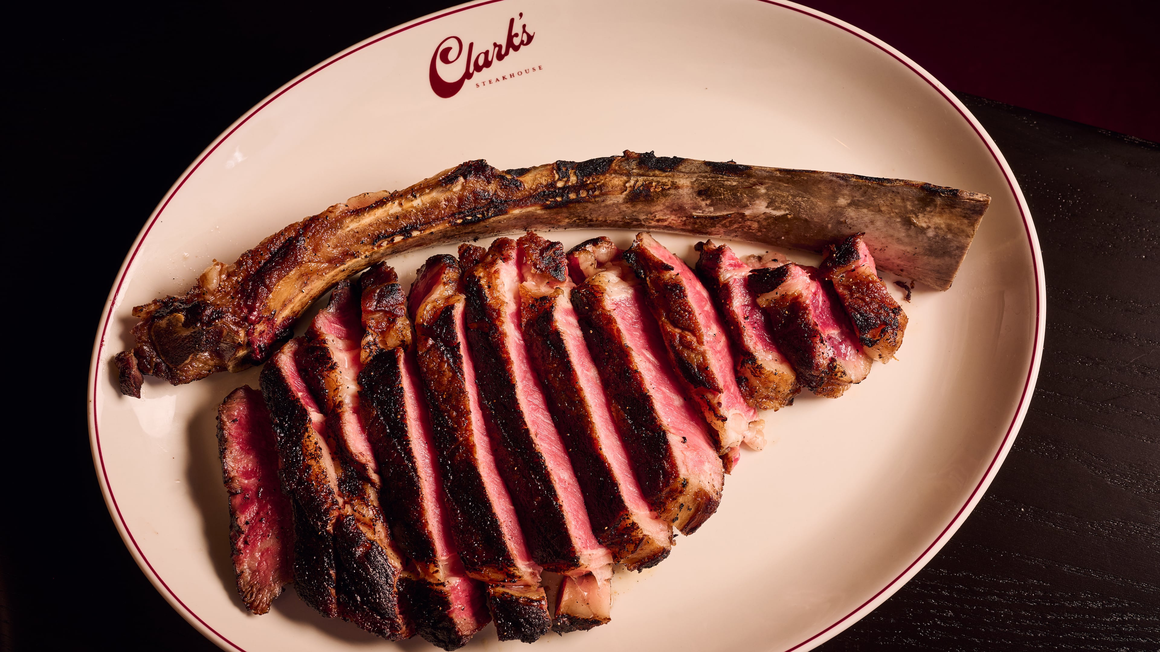The larger steaks, like this 34-ounce dry-aged tomahawk, at Clark's Steakhouse are beautifully sliced before serving. (Angie Webb/Courtesy of Clark's Steakhouse)