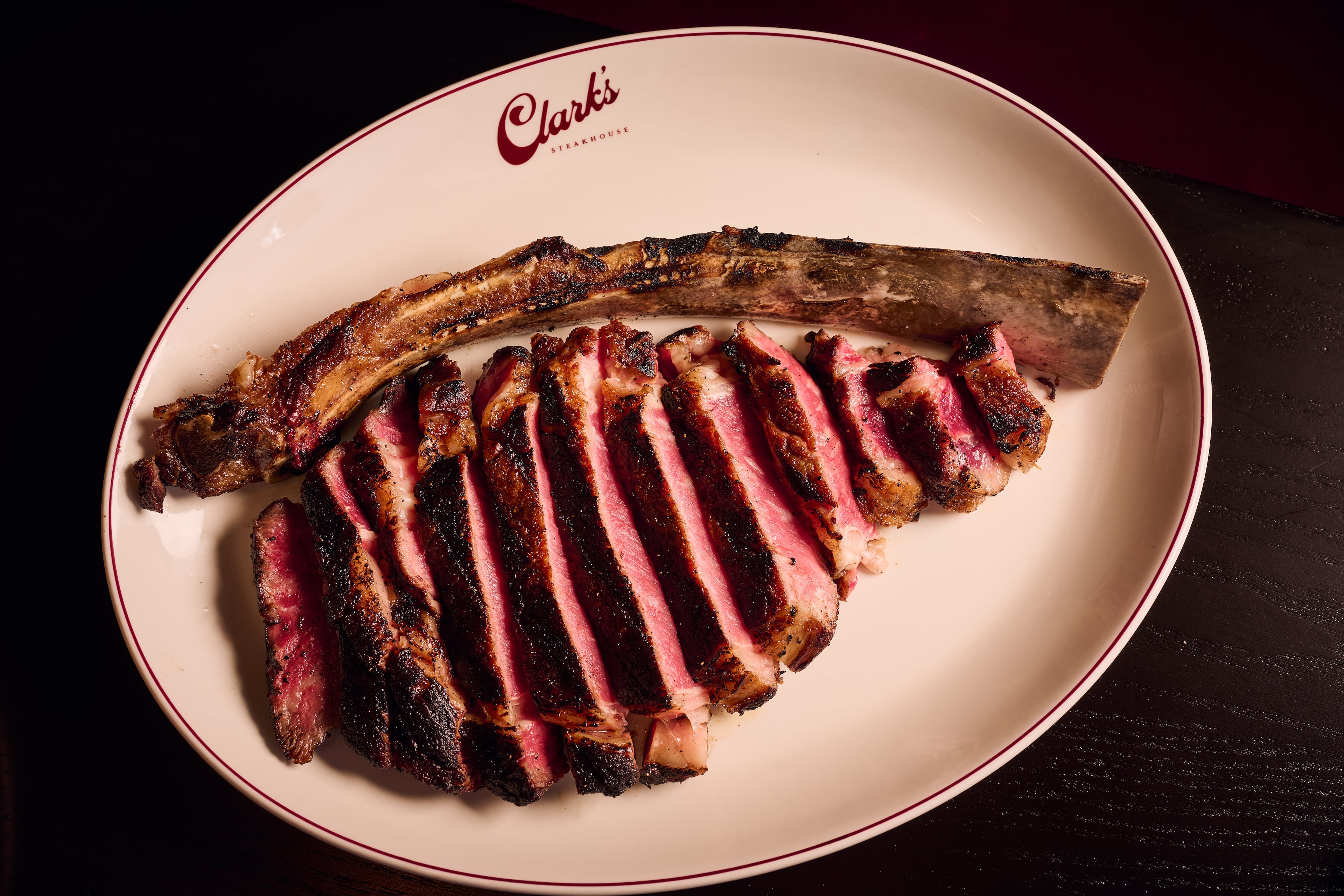 The larger steaks, like this 34-ounce dry-aged tomahawk, at Clark's Steakhouse are beautifully sliced before serving. (Angie Webb/Courtesy of Clark's Steakhouse)