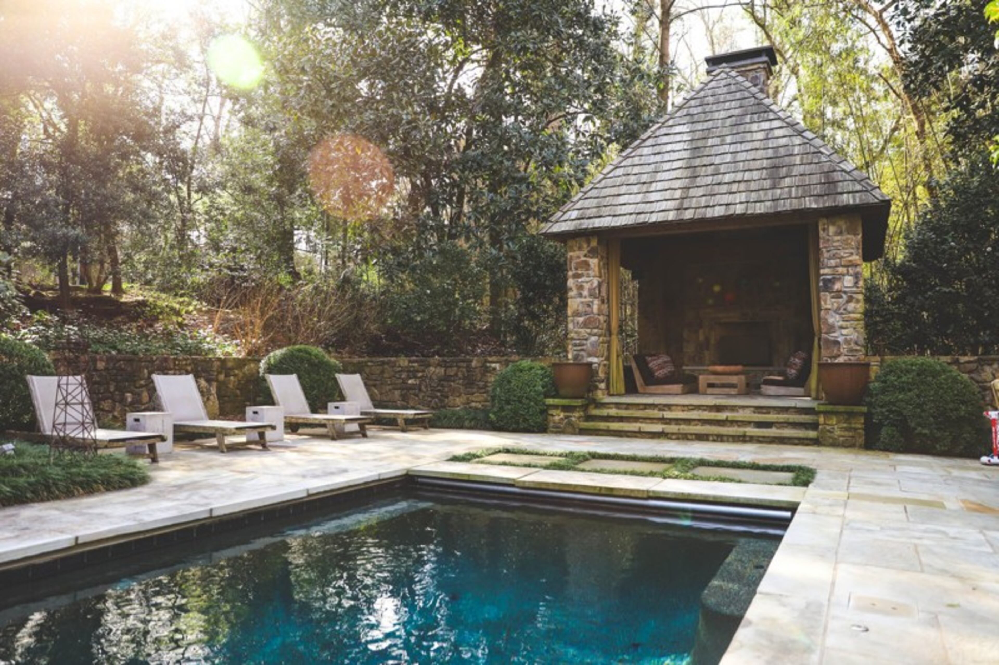 Nancy and Gene Hooff worked with William B. Litchfield Residential Designs Inc. to design their pool cabana, which has a wood burning fireplace, TV and seating from Sutherland Furniture. The couple uses their outdoor space to hold family gatherings, such as birthday parties and Easter egg hunts. Reynolds Rogers/For The AJC