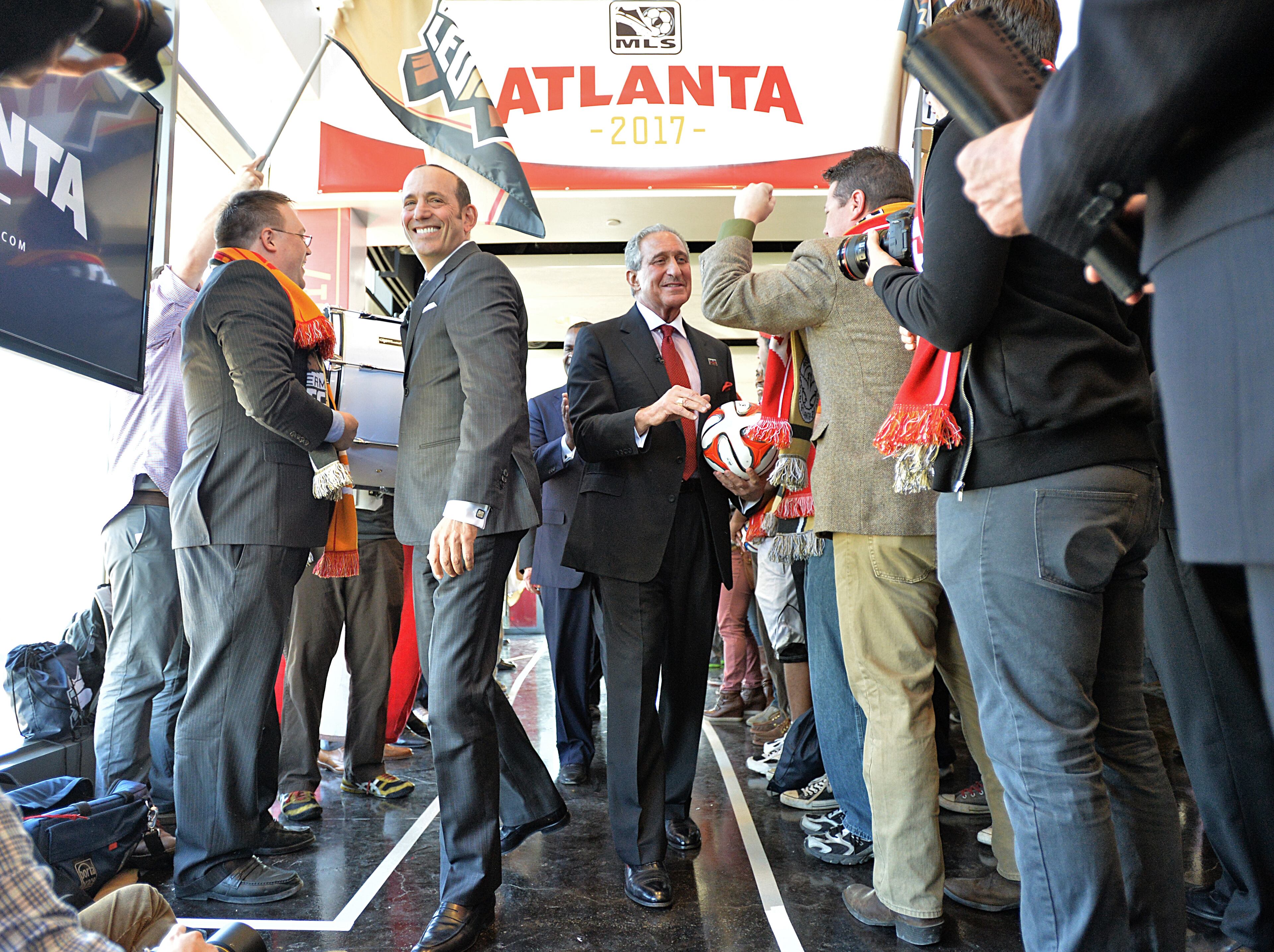 MLS commissioner Don Garber , Falcons owner Arthur Blank enter as soccer fans cheer before the official announcement event begins in downtown Atlanta on Wednesday, April 16, 2014. MLS commissioner Don Garber, Falcons owner Arthur Blank, Mayor Kasim Reed, executive director of GWCC Frank Poe and others officially announced that Atlanta will be the 22nd team in MLS on Wednesday downtown amidst a parade-like atmosphere. HYOSUB SHIN / HSHIN@AJC.COM