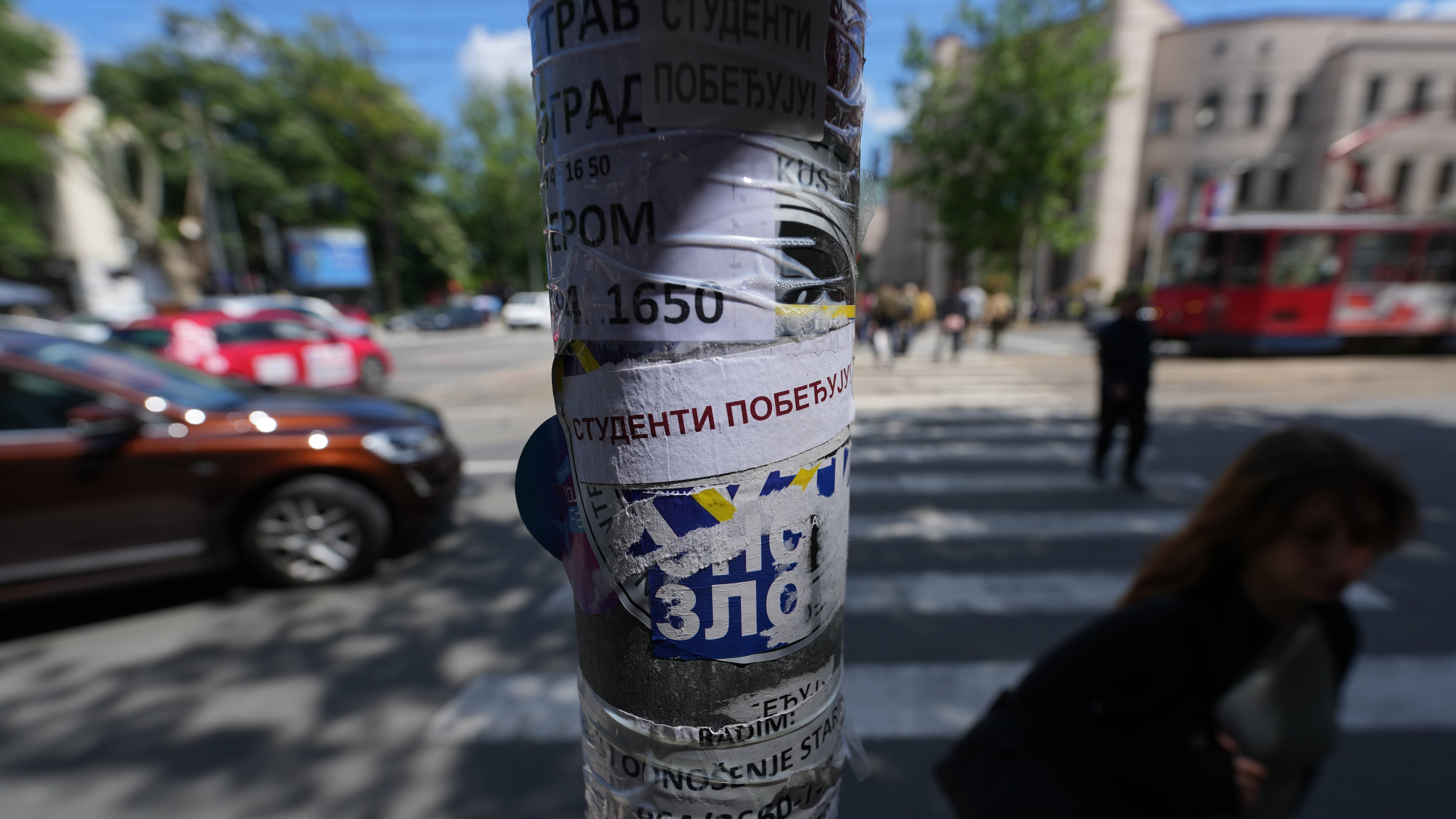 People walk by a lamppost with stickers that read: "Students win" before the first big rally this year of opponents of President Aleksandar Vucic in Belgrade, Serbia, Monday, May 18, 2026. (AP Photo/Darko Vojinovic)