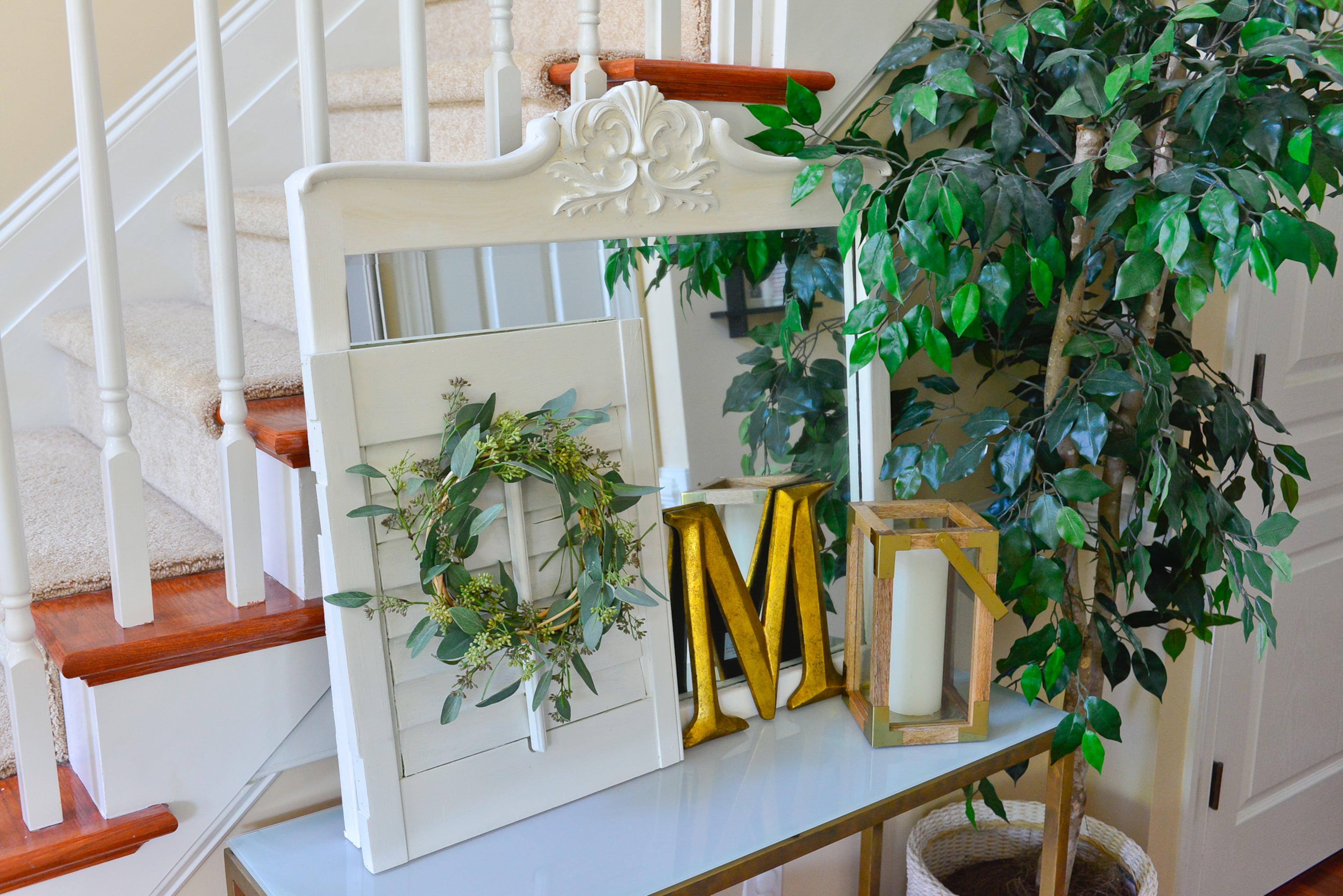 Foyer: In the foyer stands a glass table from Crate and Barrel that homeowner Yuni Min updated, using gold Rub'n Buff on the previously pewter base. The mirror was a dumpster find that's been spruced up with white chalk paint. The family initial completes the display.