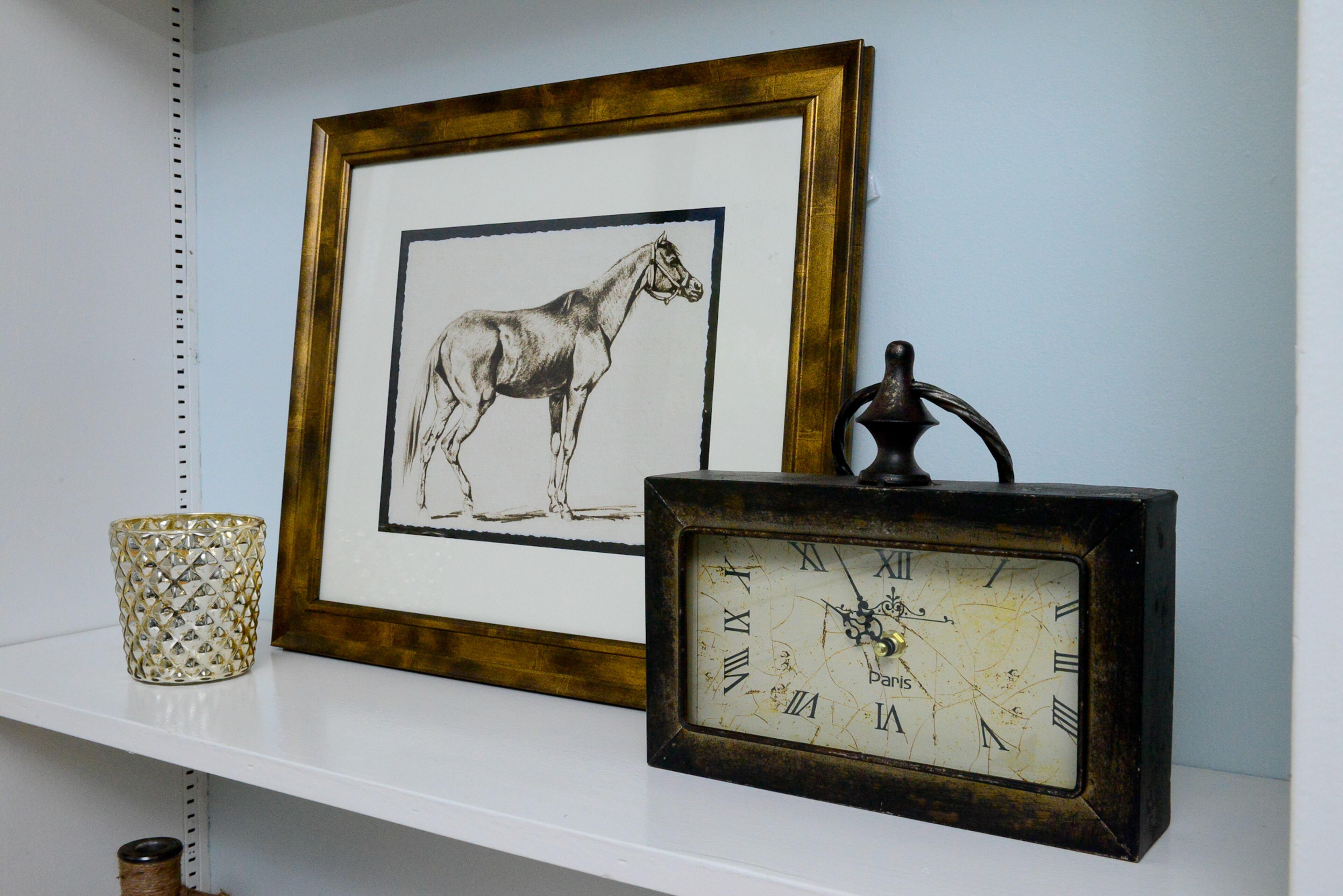 A few select items, including a horse print from HomeGoods, were selected for the built-in bookshelves, which were painted inside with a light blue hue.