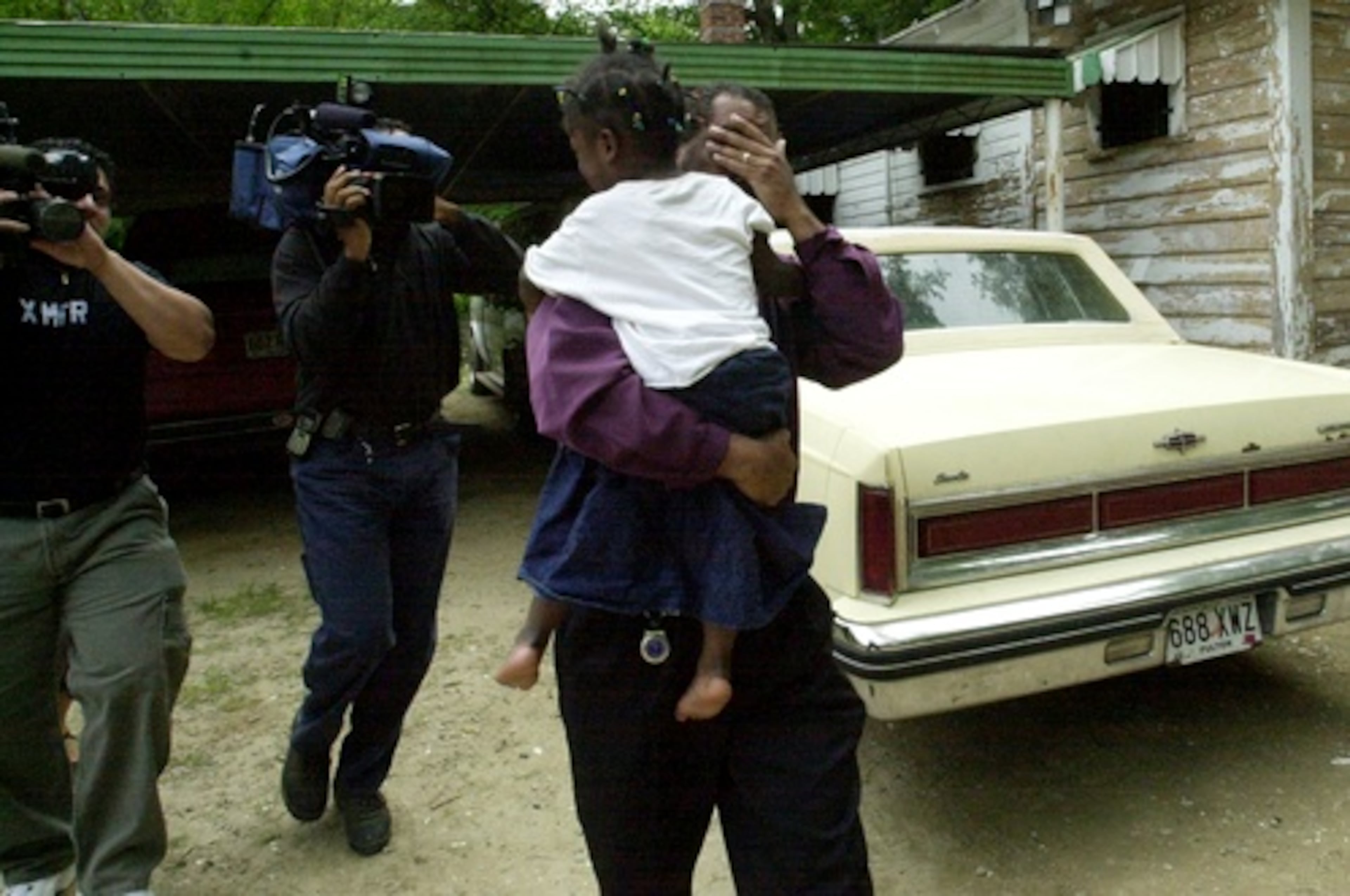 A boy is taken away, too, as TV cameras capture the separation. (KIMBERLY SMITH/FILE)