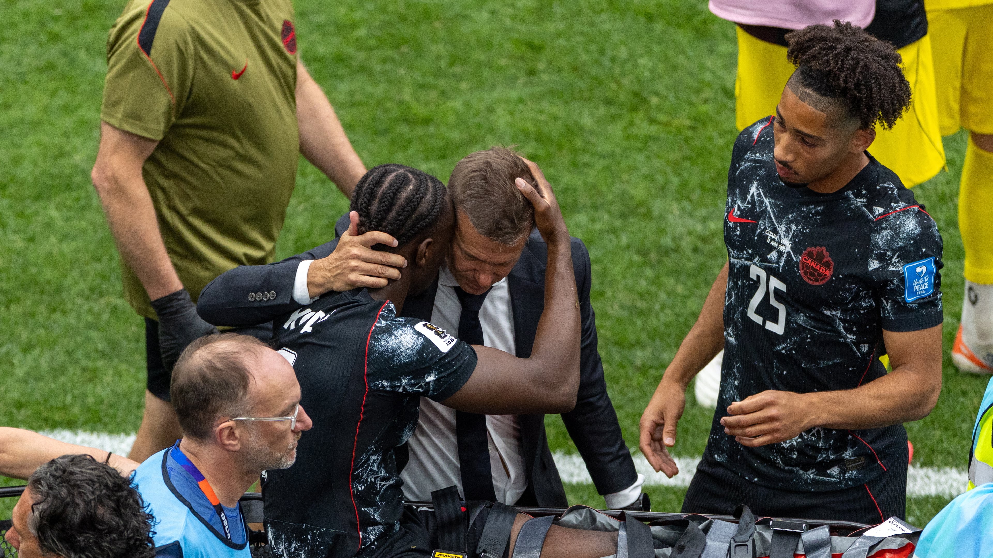 Canada head coach Jesse Marsch embraces Ismael Kone (8) as he is stretchered off the field after an injury during the World Cup Group B soccer match between Canada and Qatar in Vancouver, British Columbia, Thursday, June 18, 2026. (Timothy Matwey/The Canadian Press via AP)