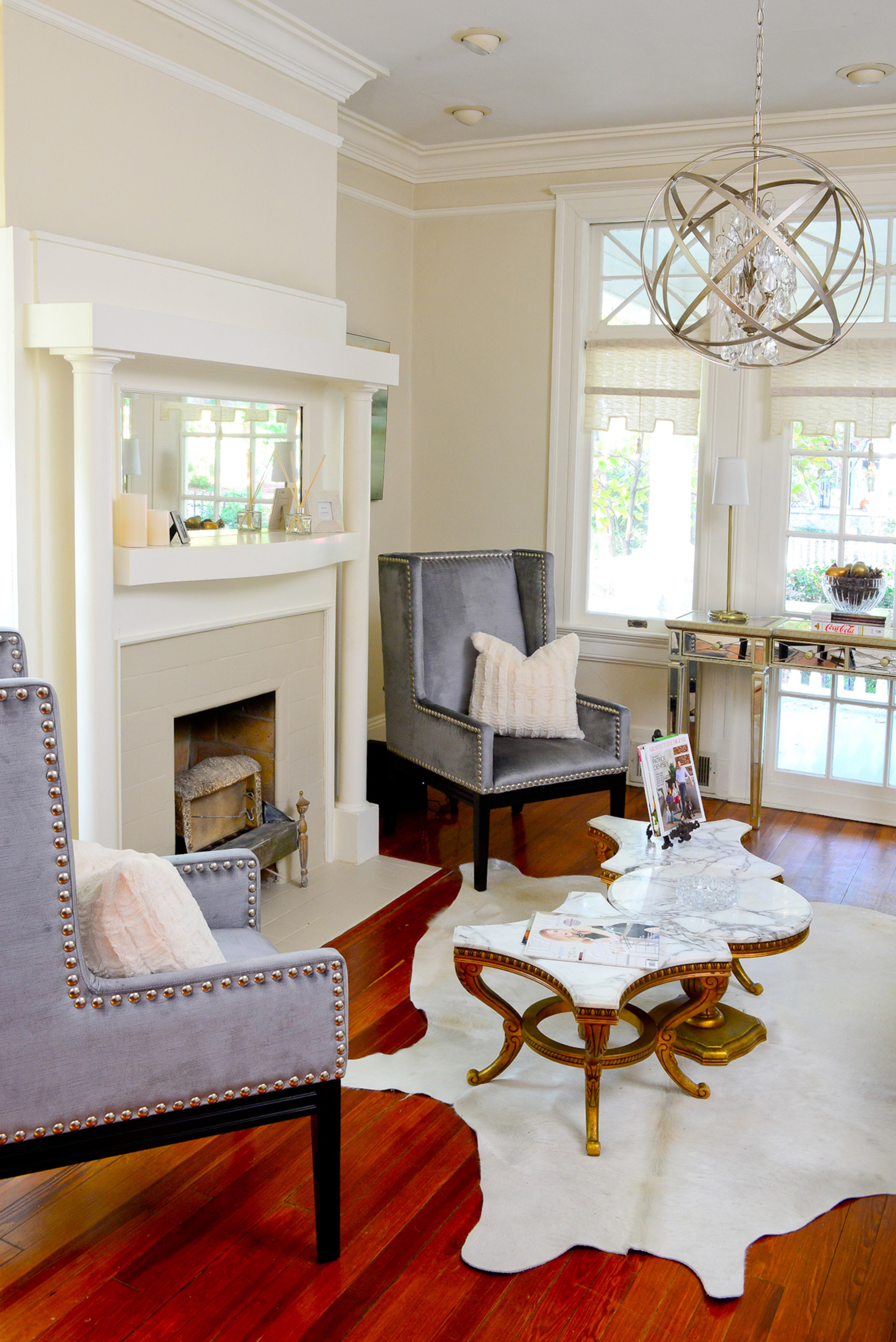 The lines of furniture and lighting bring a sense of movement into the living room. A French marble coffee table, from Atlanta's Paris on Ponce, is on top of a cowhide rug from Rina Norwood Design. The creamy palette continues with the fireplace mantle, surround and walls. “Everything about the space visually reflects my taste of the classic past and yet it presents itself to contemporary setting,” the homeowner said.