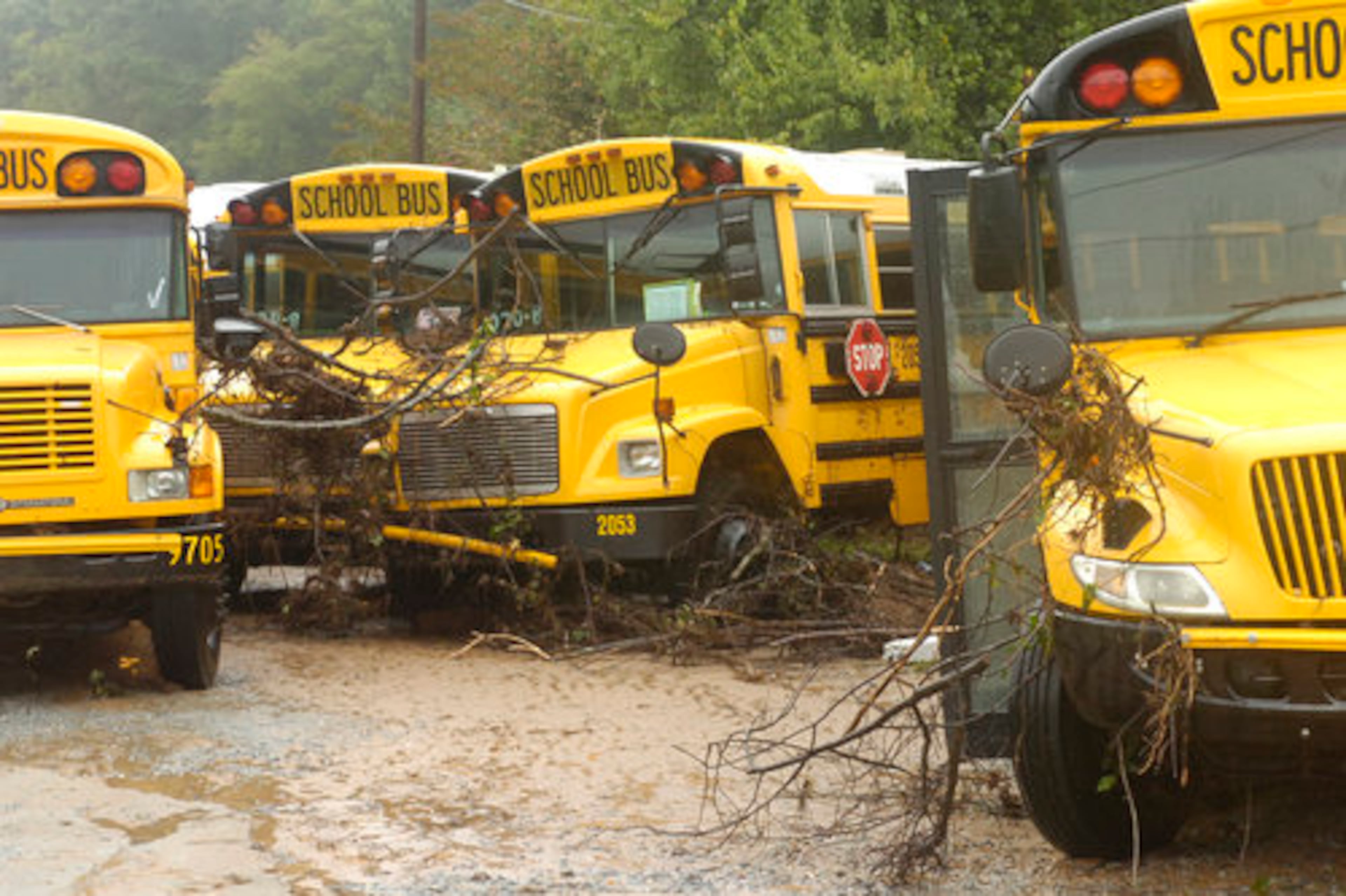 Debris swept through by flood waters rests on buses on Cole Drive near Parkview High School in Lilburn.