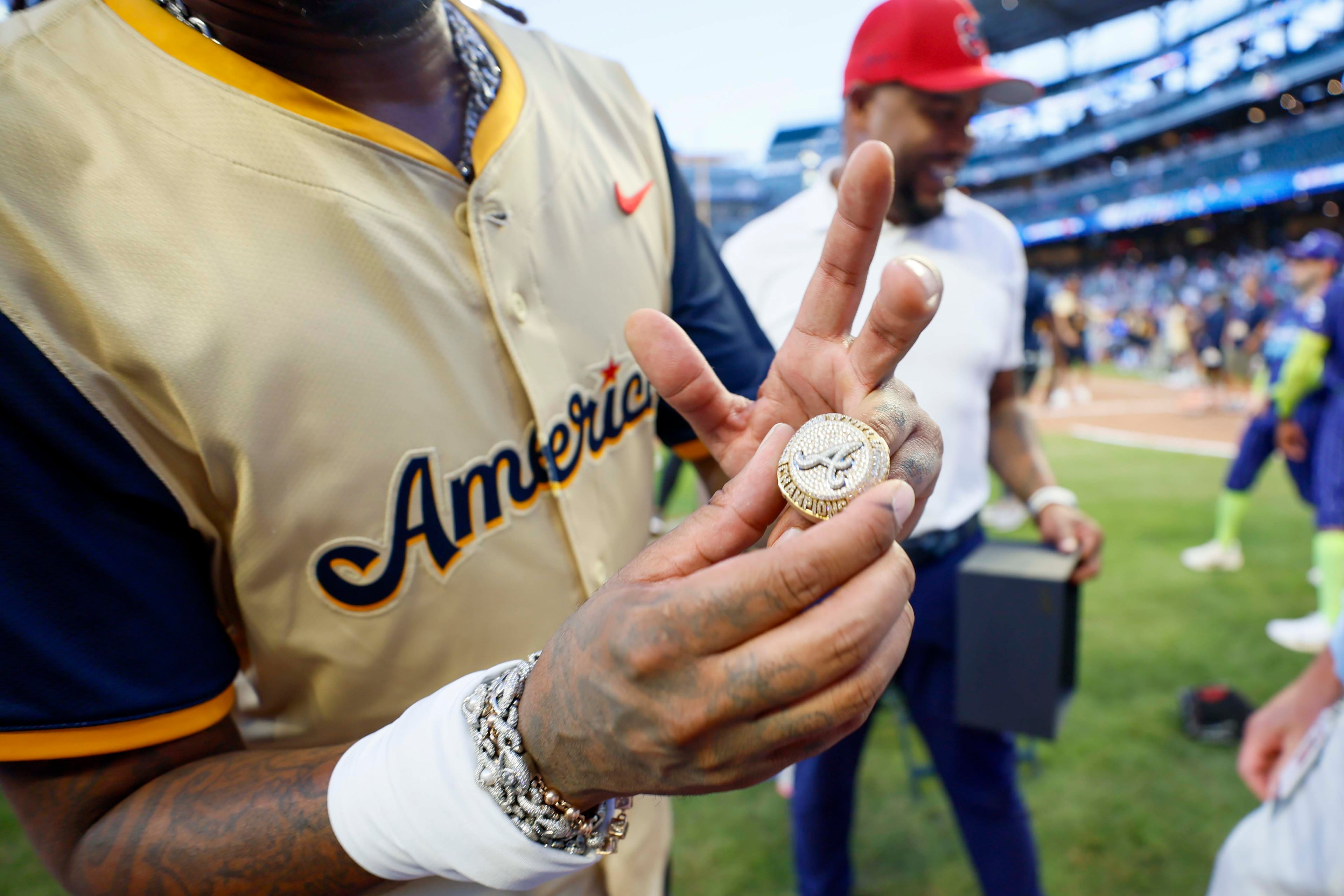 Atlanta rapper Quavo showcases the 2021 Atlanta Braves championship ring after being surprised with a special gift by Derek Schiller, President & CEO of the Atlanta Braves, and former Braves player Andrew Jones during the MLB All-Star Celebrity Game at Truist Park on Saturday, July 12, 2025, in Atlanta.
(Miguel Martinez/ AJC)