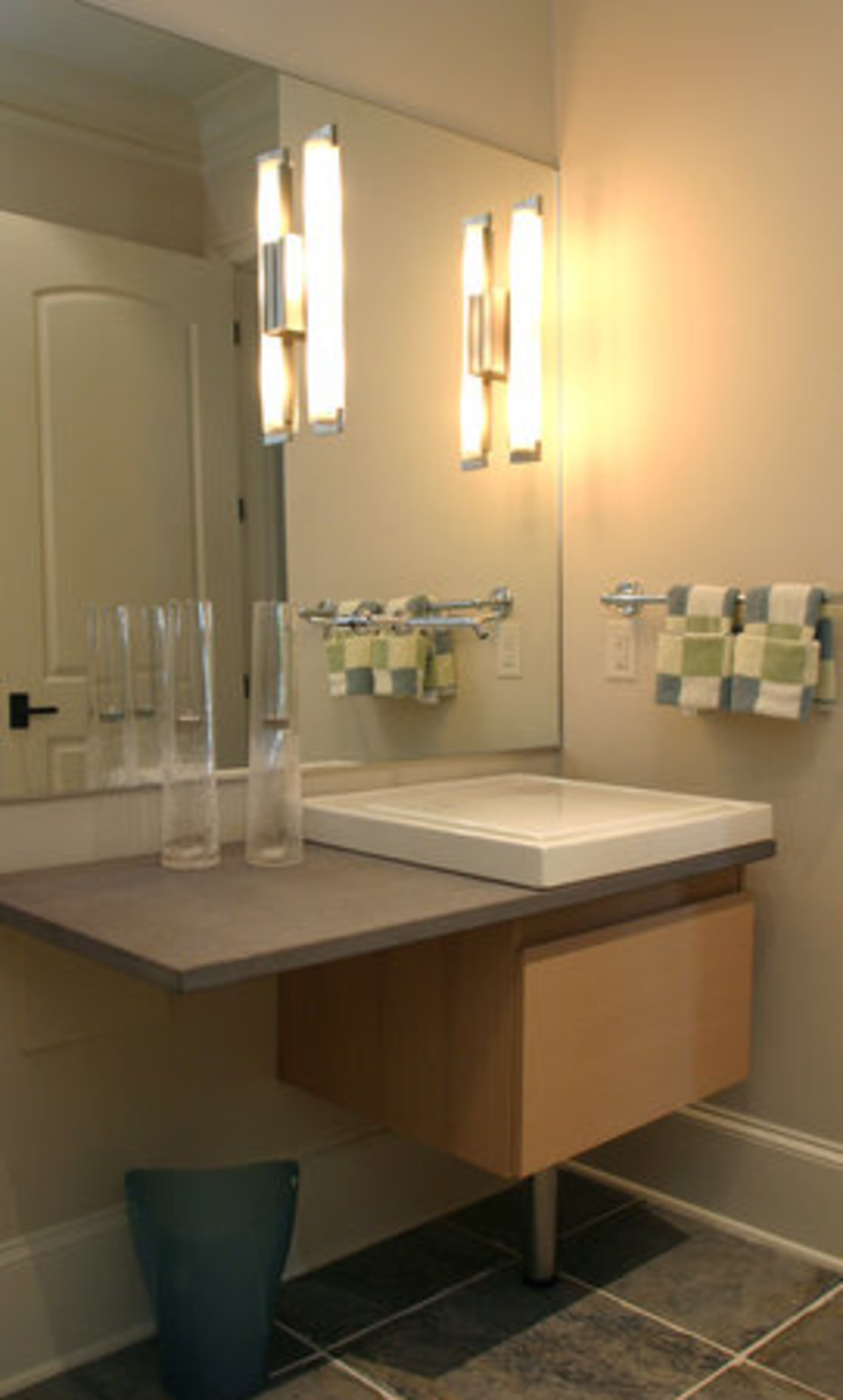 The poolside area on the basement level was inspired by spa design. The area is equipped with spa sinks, his-and-her changing rooms, lockers and showers. "It's been very functional for when we entertain around the pool." The flooring comprises glass blocks with traditional slate.