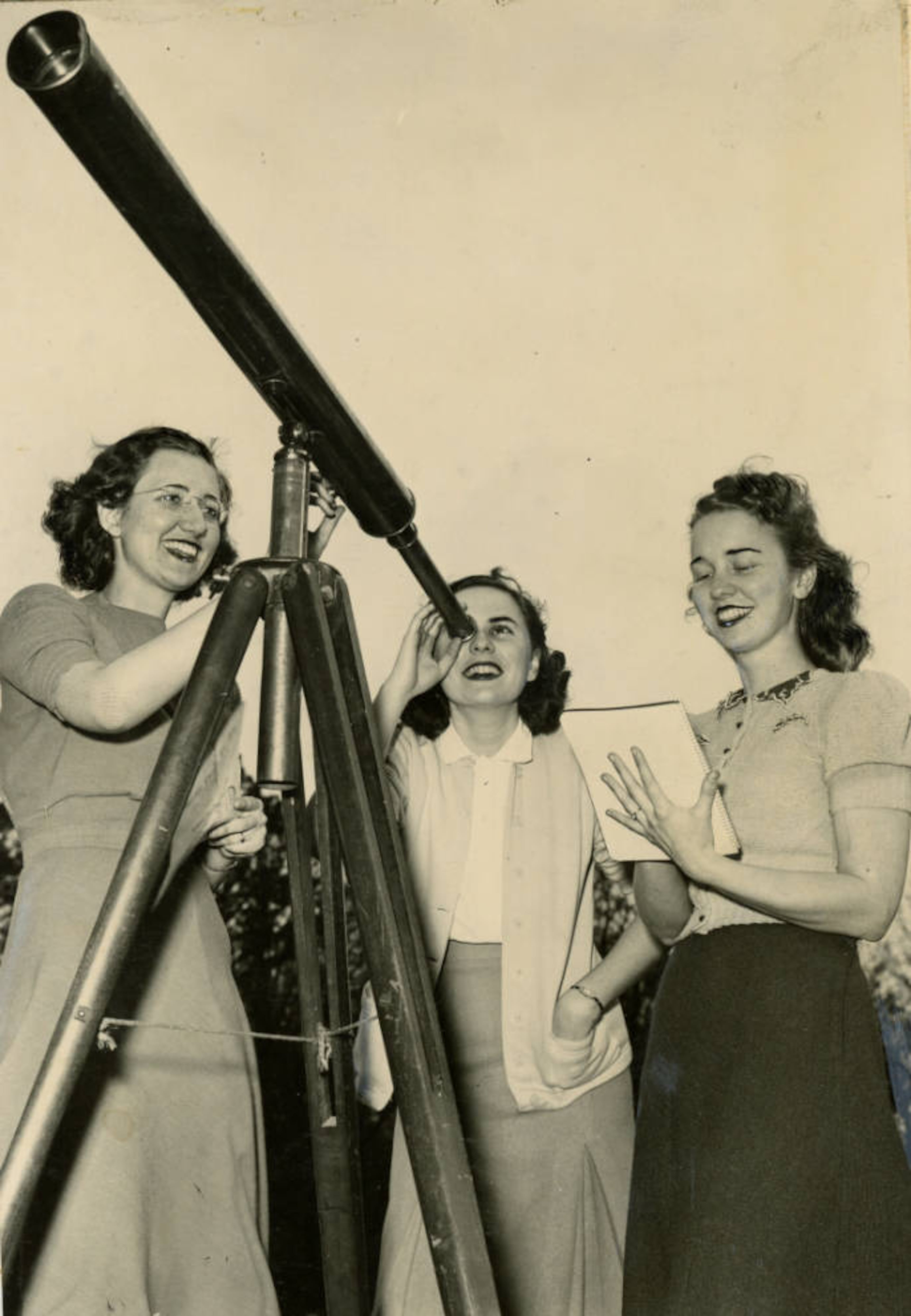 Students and professor at Agnes Scott College in Decatur, looking through telescope, April 1940. AJC file
