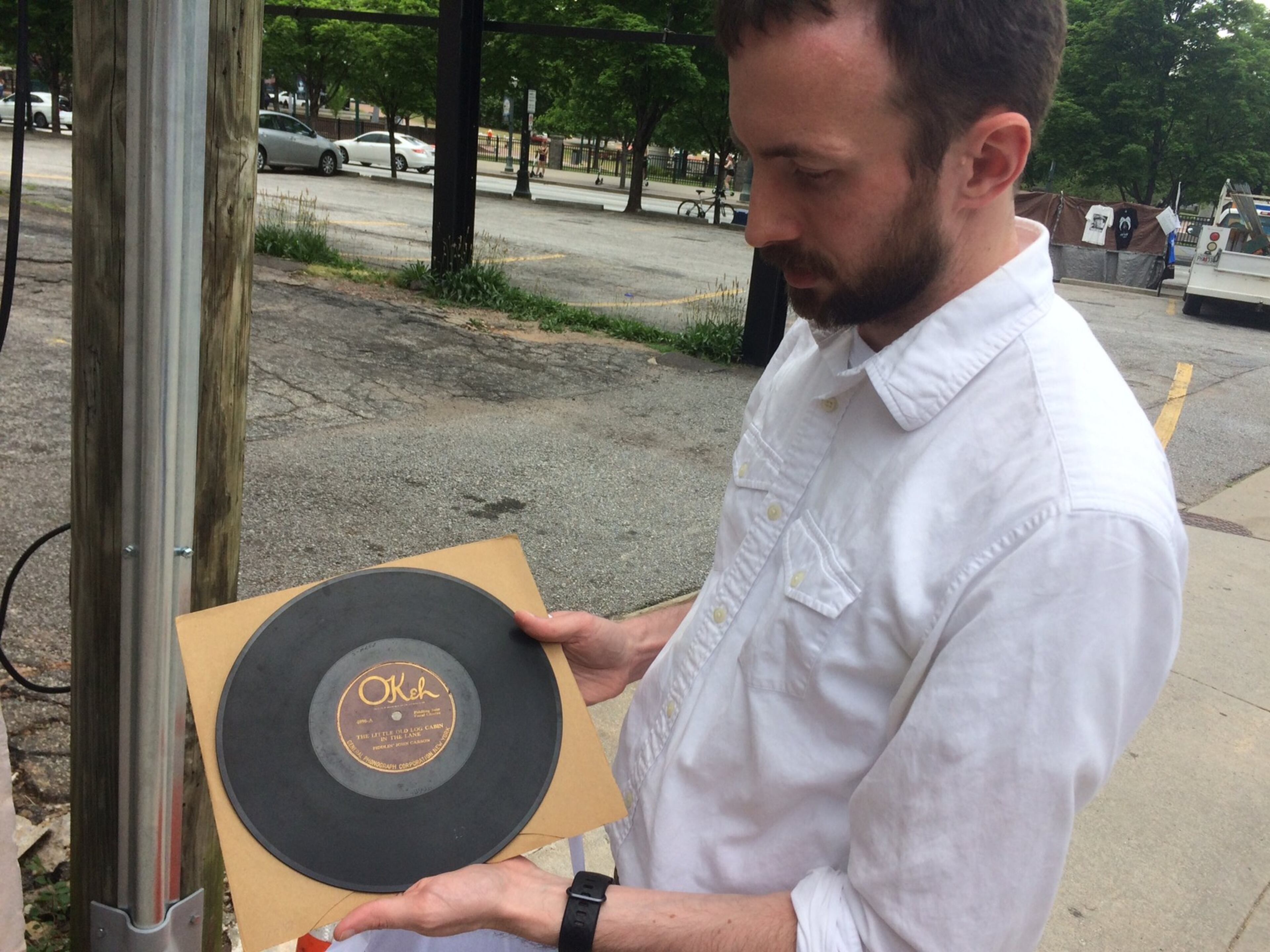 Kyle Kessler, a downtown resident and preservationist who started the effort to save 152 Nassau Street, holds a copy of the first country music hit, a song recorded at that building.