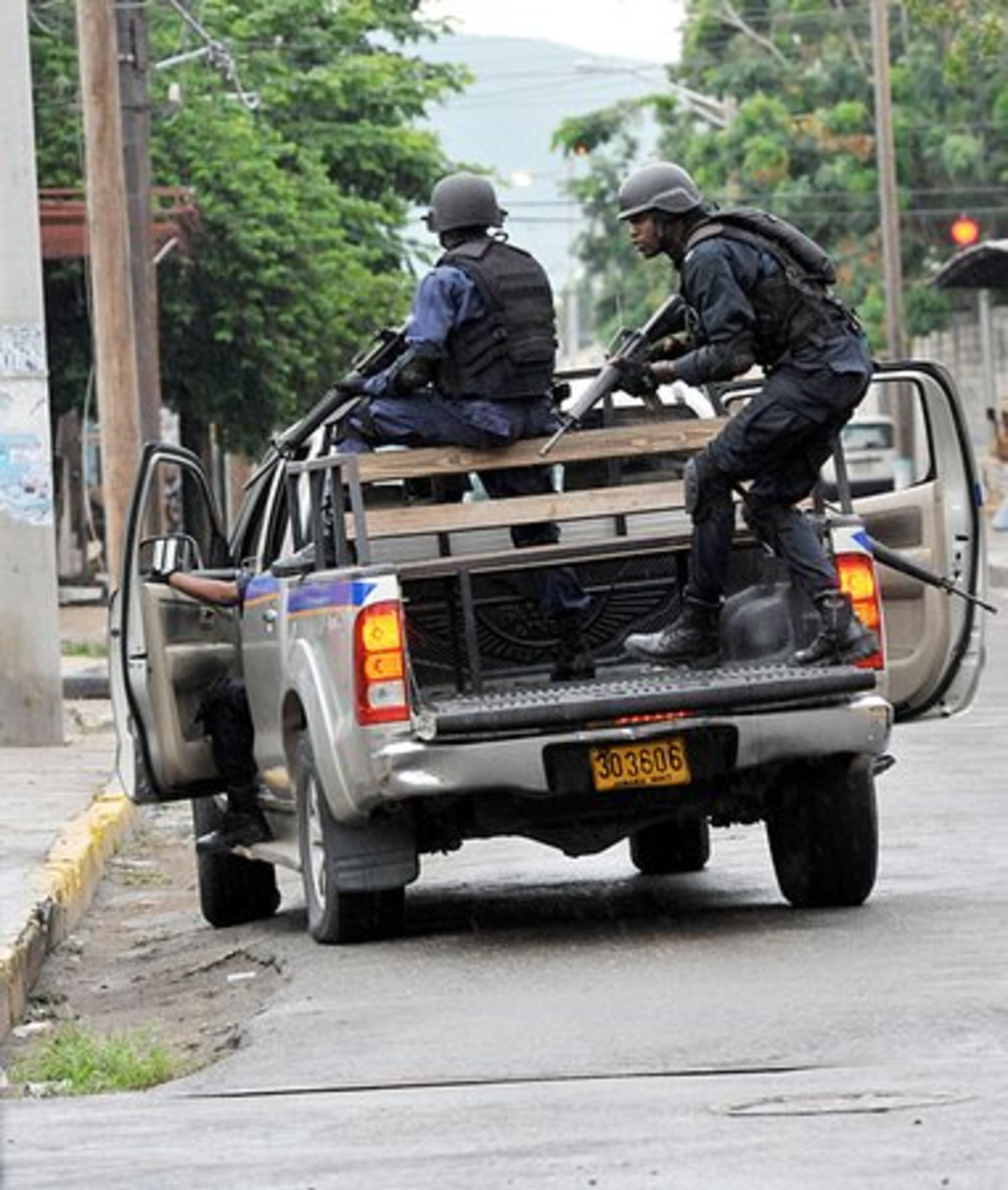 Police prepare to leave their vehicle while patroling on North Street in Kingston, Jamaica.
