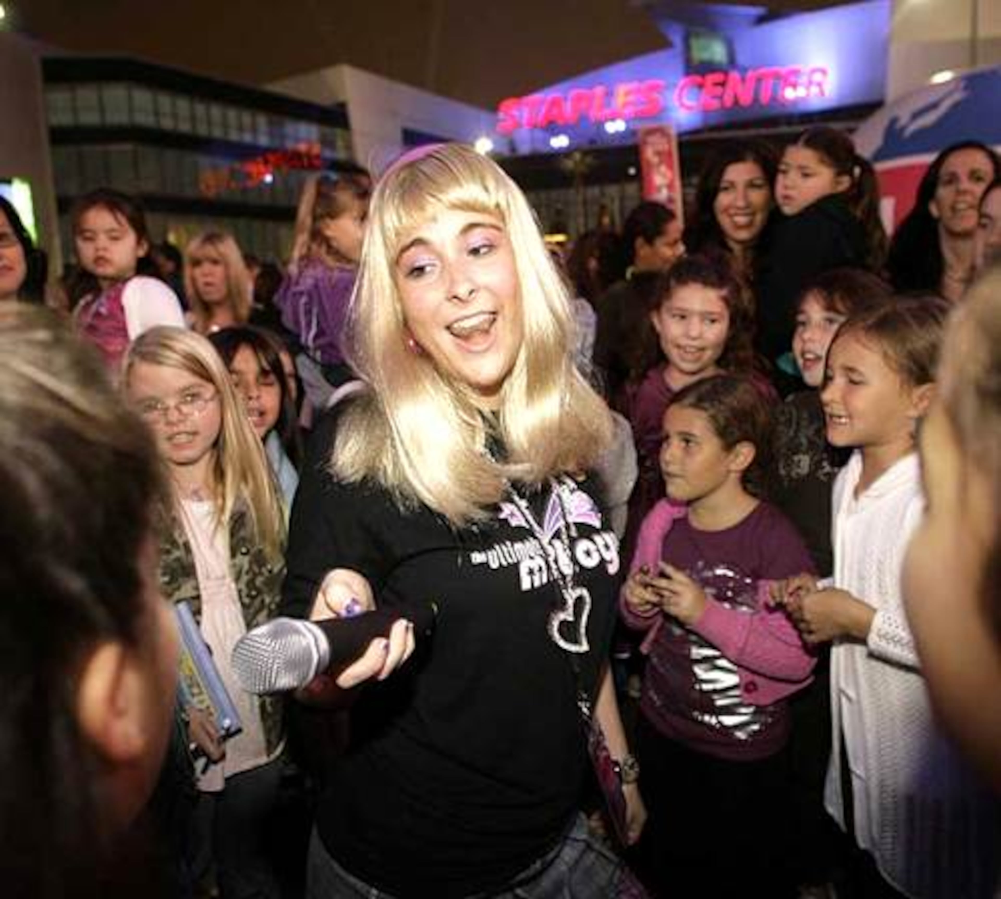 Mileyworld Girl Rebecca Mines holds the microphone while fans of Miley Cyrus sing karaoke as they participate in the Ultimate Miley Party Bus Tour 2007 in Los Angeles.