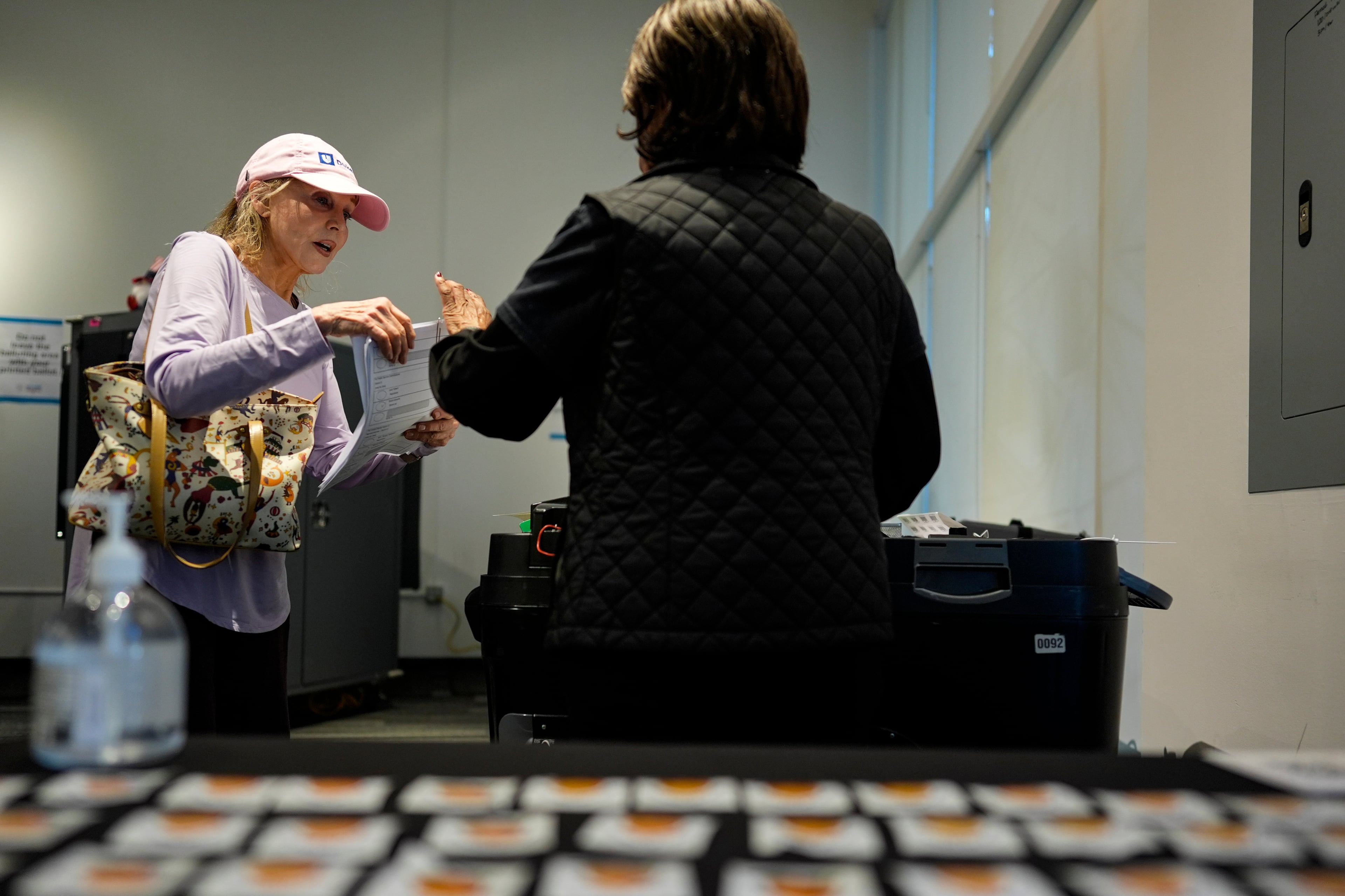 A voter hands her paper ballot to an election worker at The High Museum of Art voting center in Atlanta on the first day for early voting in Georgia last week. (Mike Stewart/AP)