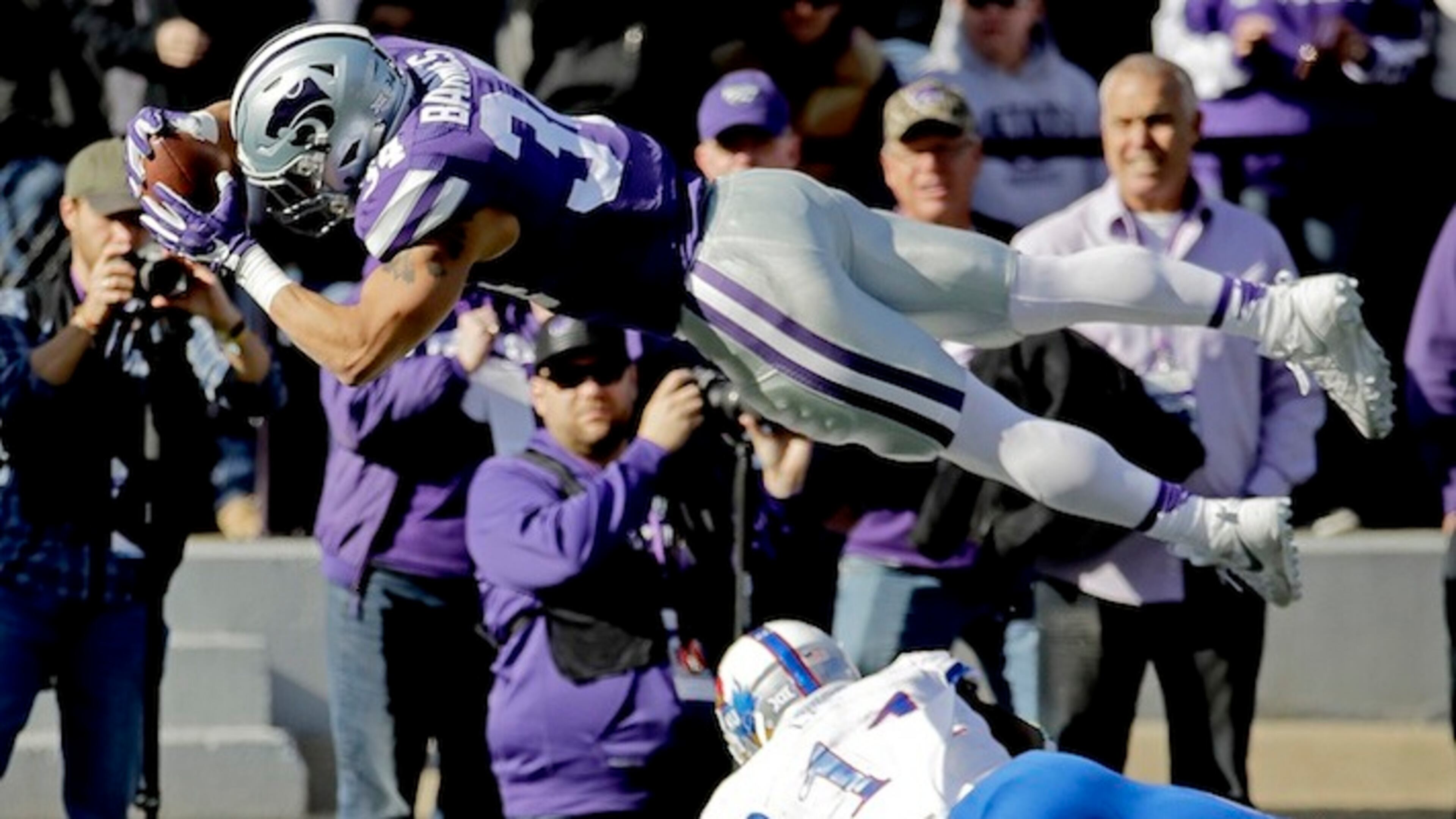 FILE - In this Nov. 26, 2016, file photo, Kansas State running back Alex Barnes (34) dives into the end zone over Kansas linebacker Mike Lee (11) to score a touchdown during the first half of an NCAA college football game, in Manhattan, Kan. After beginning last season buried on the depth chart, Barnes wound up rushing for 442 yards and six touchdowns on just 56 carries. That was good enough for second in school history in both categories by a freshman running back. (AP Photo/Charlie Riedel, File)
