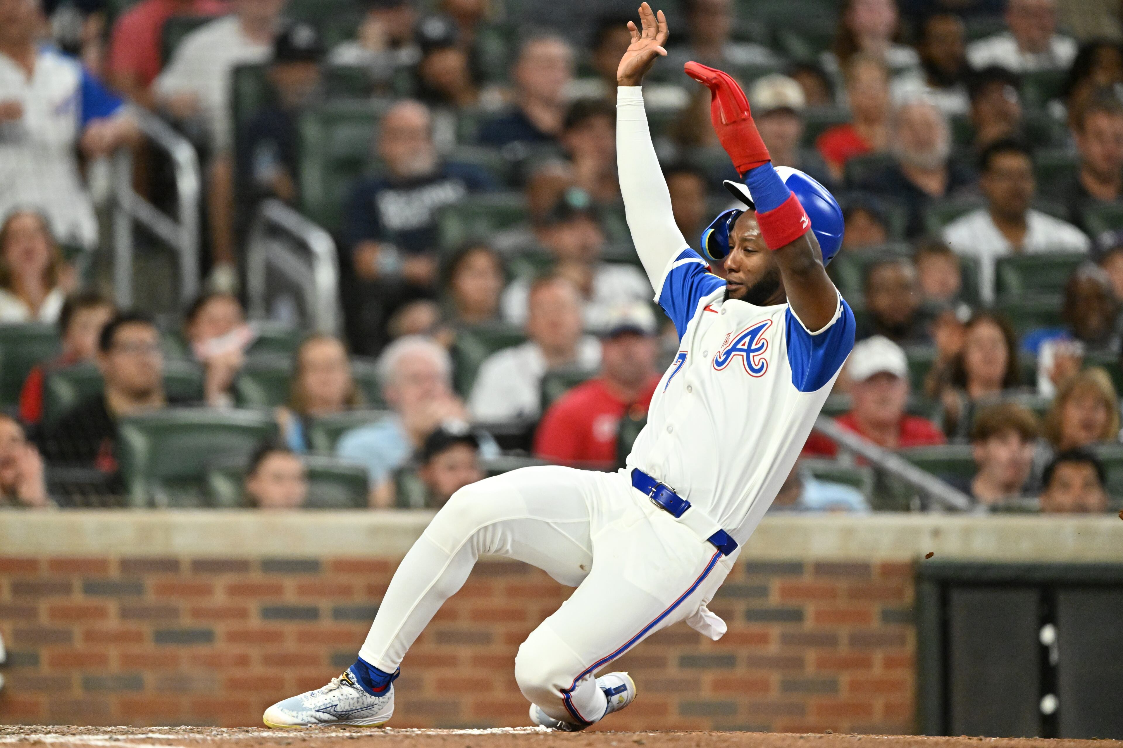Atlanta Braves outfielder Jurickson Profar (7) slides into home base safely on an RBI single by Atlanta Braves first base Matt Olson (28) during the sixth inning of a baseball game at Truist Park, Saturday, July 19, 2025, in Atlanta. New York Yankees won 12-9 over Atlanta Braves. (Hyosub Shin / AJC)