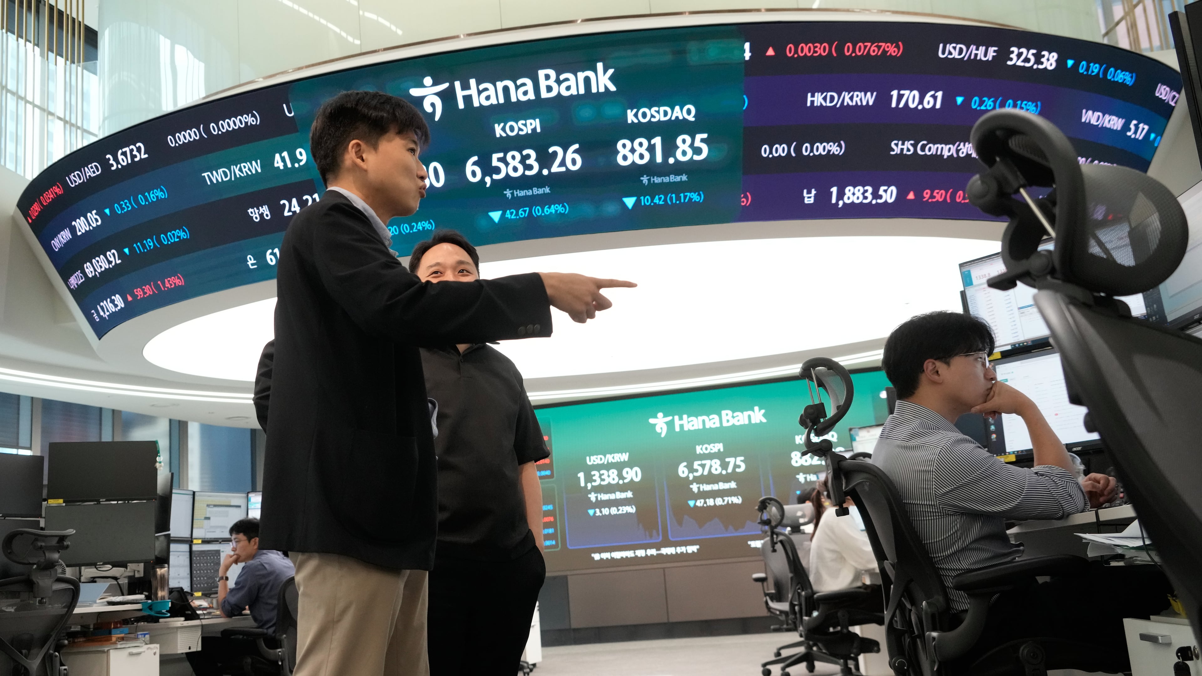 Currency traders work at the foreign exchange dealing room of the Hana Bank headquarters in Seoul, South Korea, Monday, Oct. 12, 2026. (AP Photo/Ahn Young-joon)