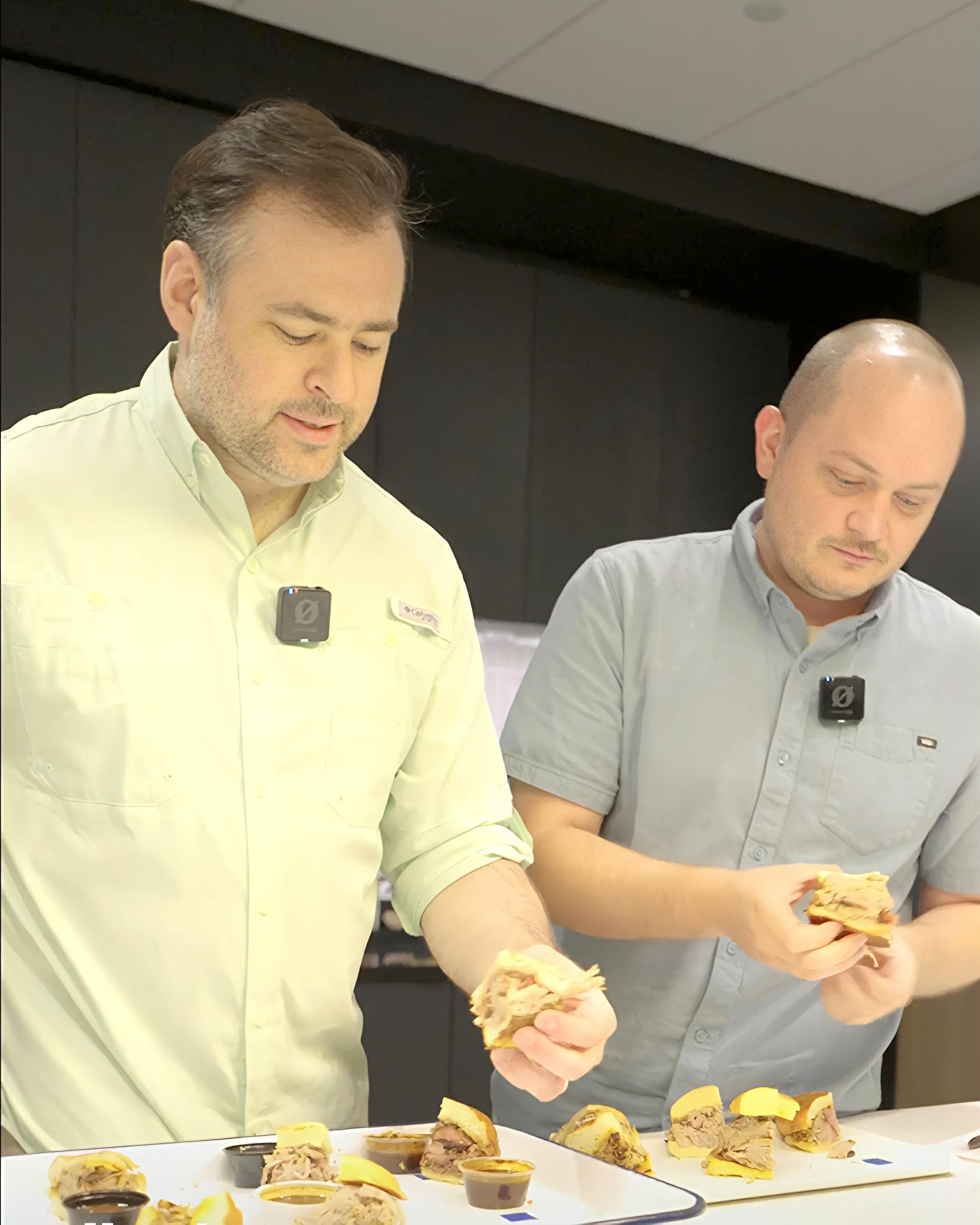AJC Food Critic Henri Hollis and AJC Video Operations Manager John Kushnerick each pick up the first contender for Best Pulled Pork Sandwich at the AJC kitchen on Thursday, June 18, 2026. (Ellen Rolfes/AJC)