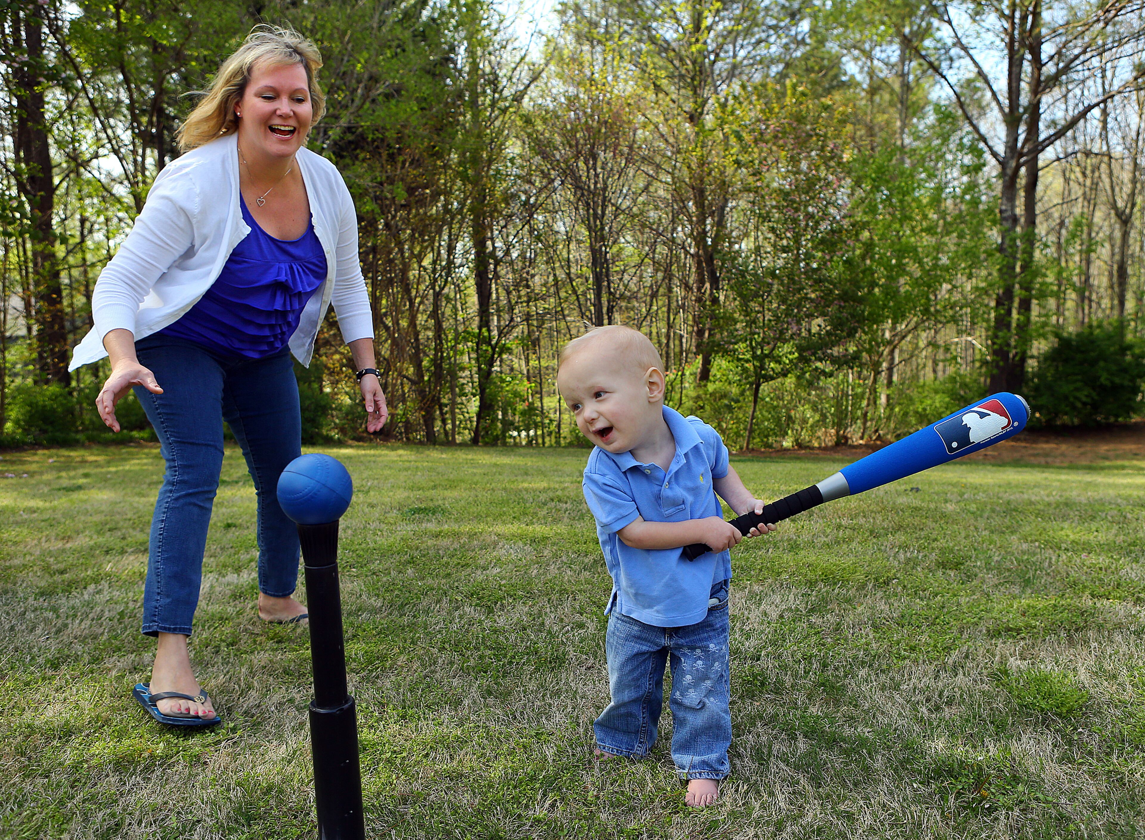 Ashley Shepardson plays t-ball with her 22-month old son Zach, who has congenital heart disease, in the front yard of their family home in Milton. CURTIS COMPTON / CCOMPTON@AJC.COM