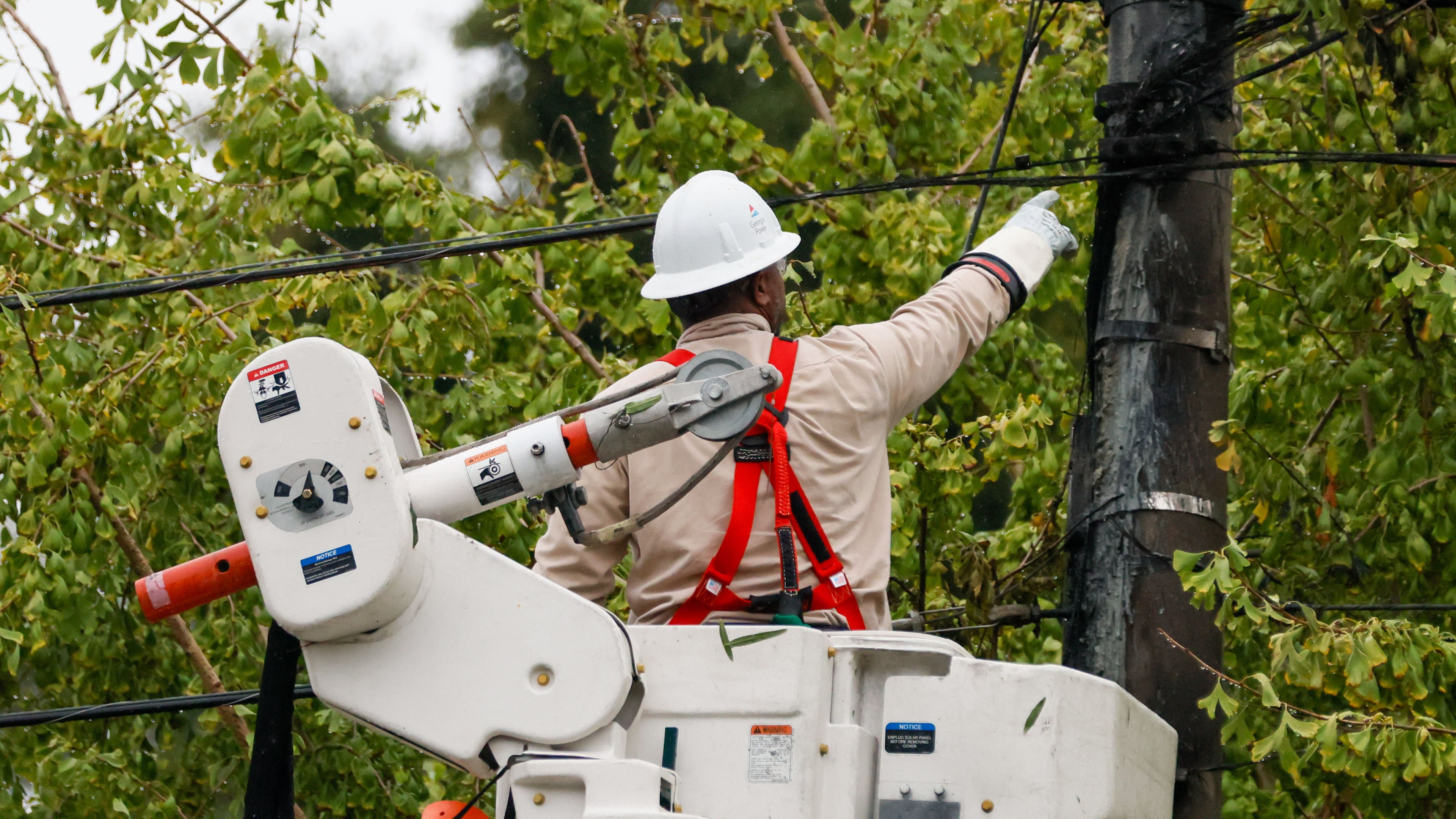 A worker works on power lines at Hill Street in Grant Park. The average customer will save $4.04 monthly thanks to agreement between the PSC and Georgia Power. (Miguel Martinez/AJC)