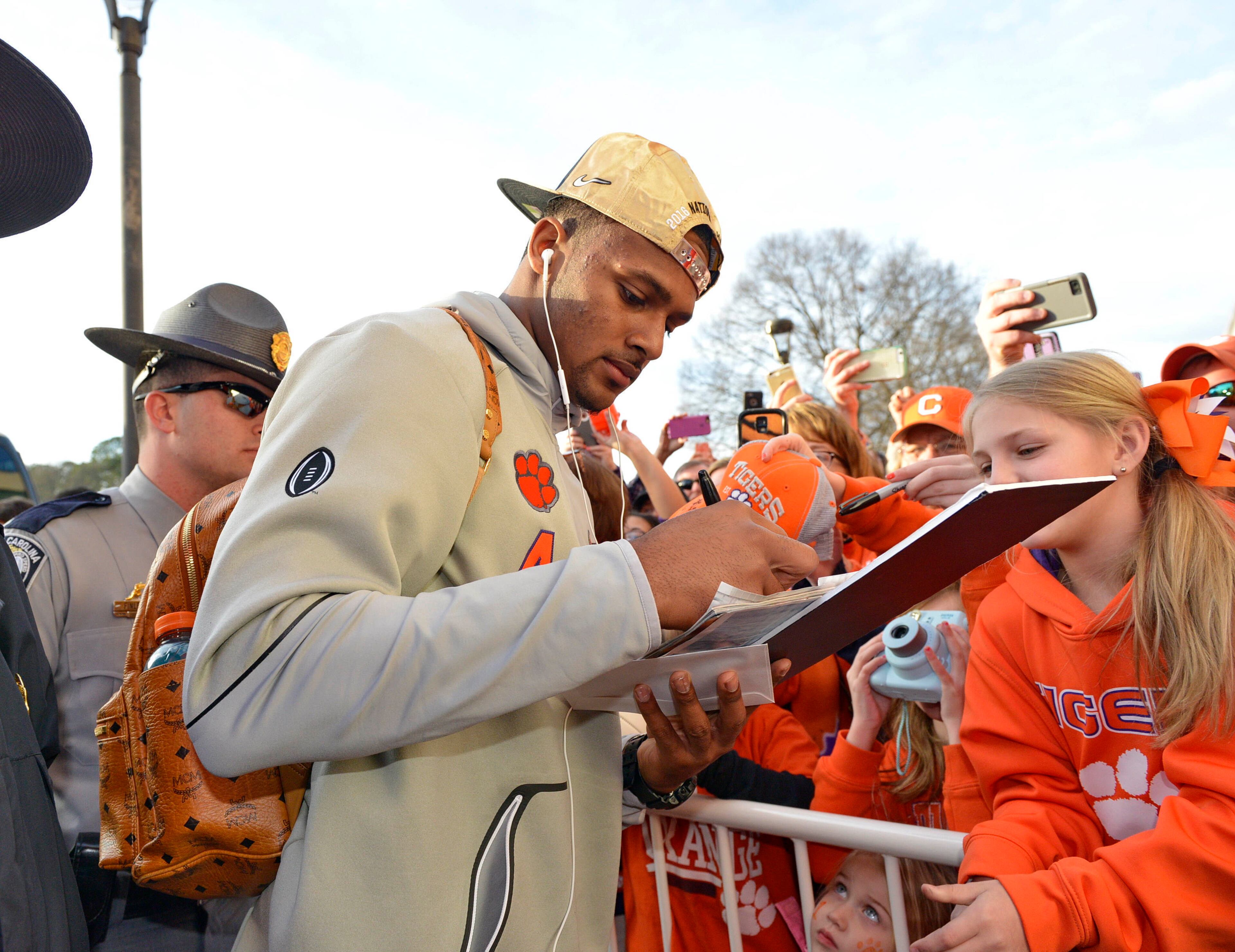 Clemson's Deshaun Watson signs autographs for fans after returning, Tuesday, Jan. 10, 2017, in Clemson, S.C., the day after the Tigers defeated Alabama 35-31 in the College Football Playoff championship NCAA college football game in Tampa, Fla. (AP Photo/Richard Shiro)