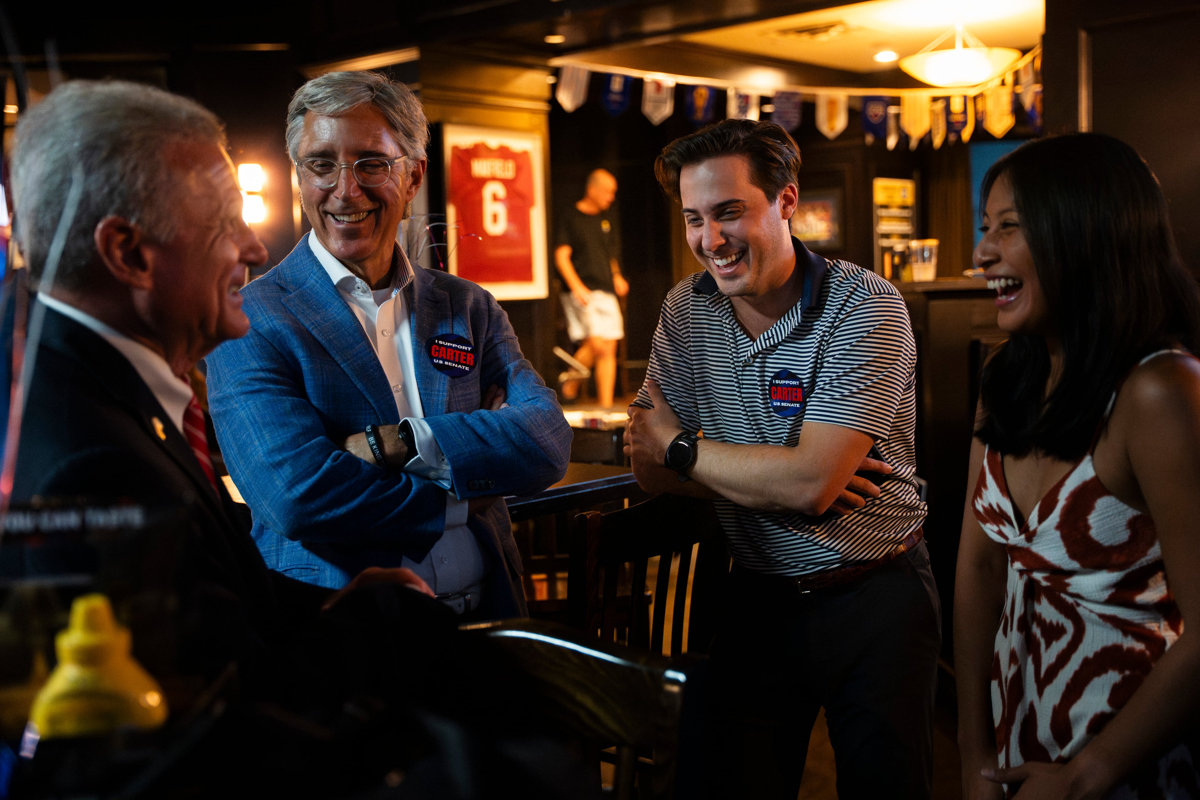 Buddy Carter chats and laughs with supporters Greg Null, left, Porter Null, center, campaign communications director, and Ellie Null, right, during an election night watch party on Tuesday, May 19, 2026, in Sandy Springs, Ga. (Olivia Bowdoin for the AJC)