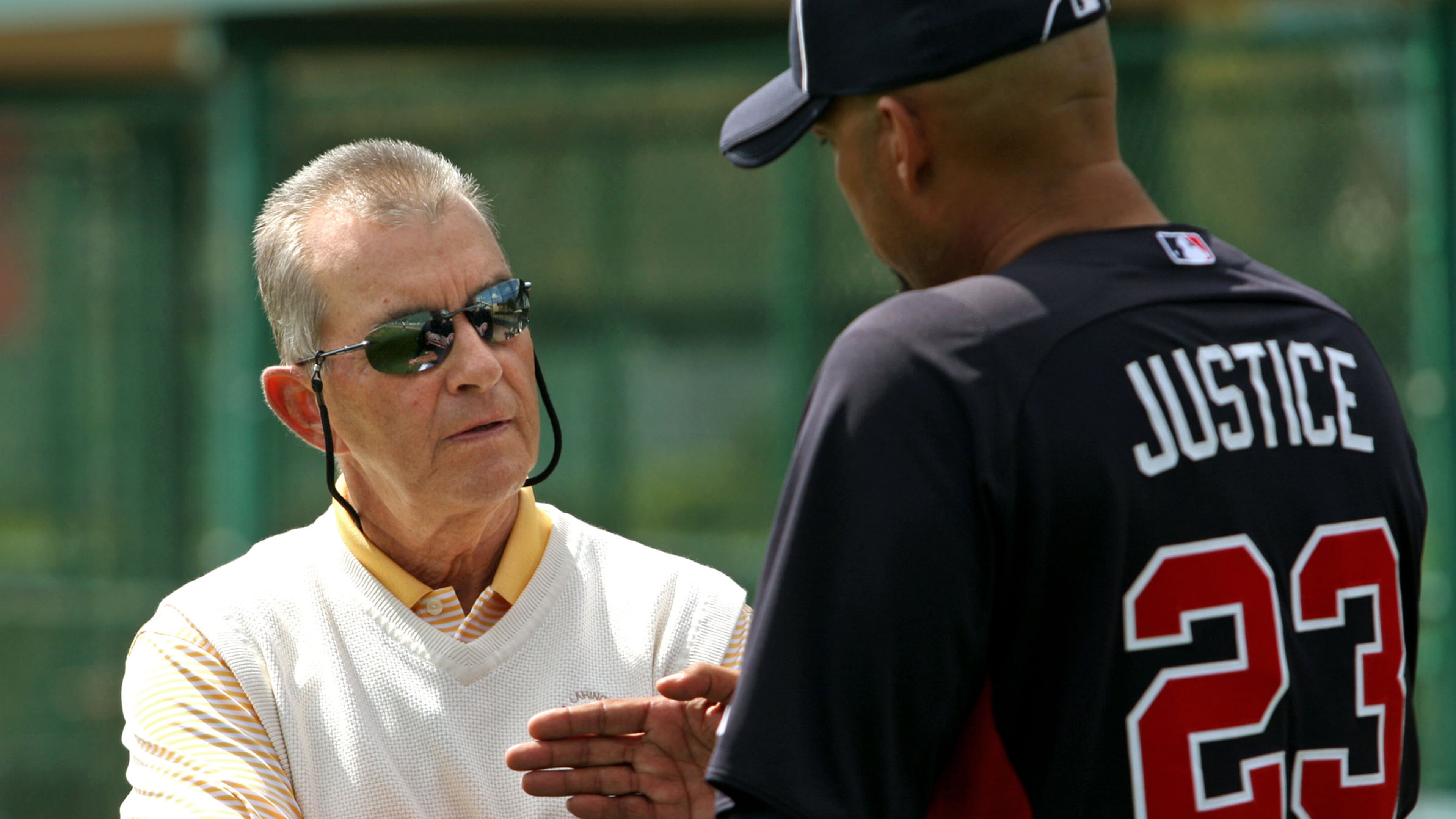 Braves president John Schulhotz, left, talks with former Brave David Justice in spring training in 2012, more than 15 years after Schuerholz traded to Justice to Cleveland. Jason Getz / AJC file