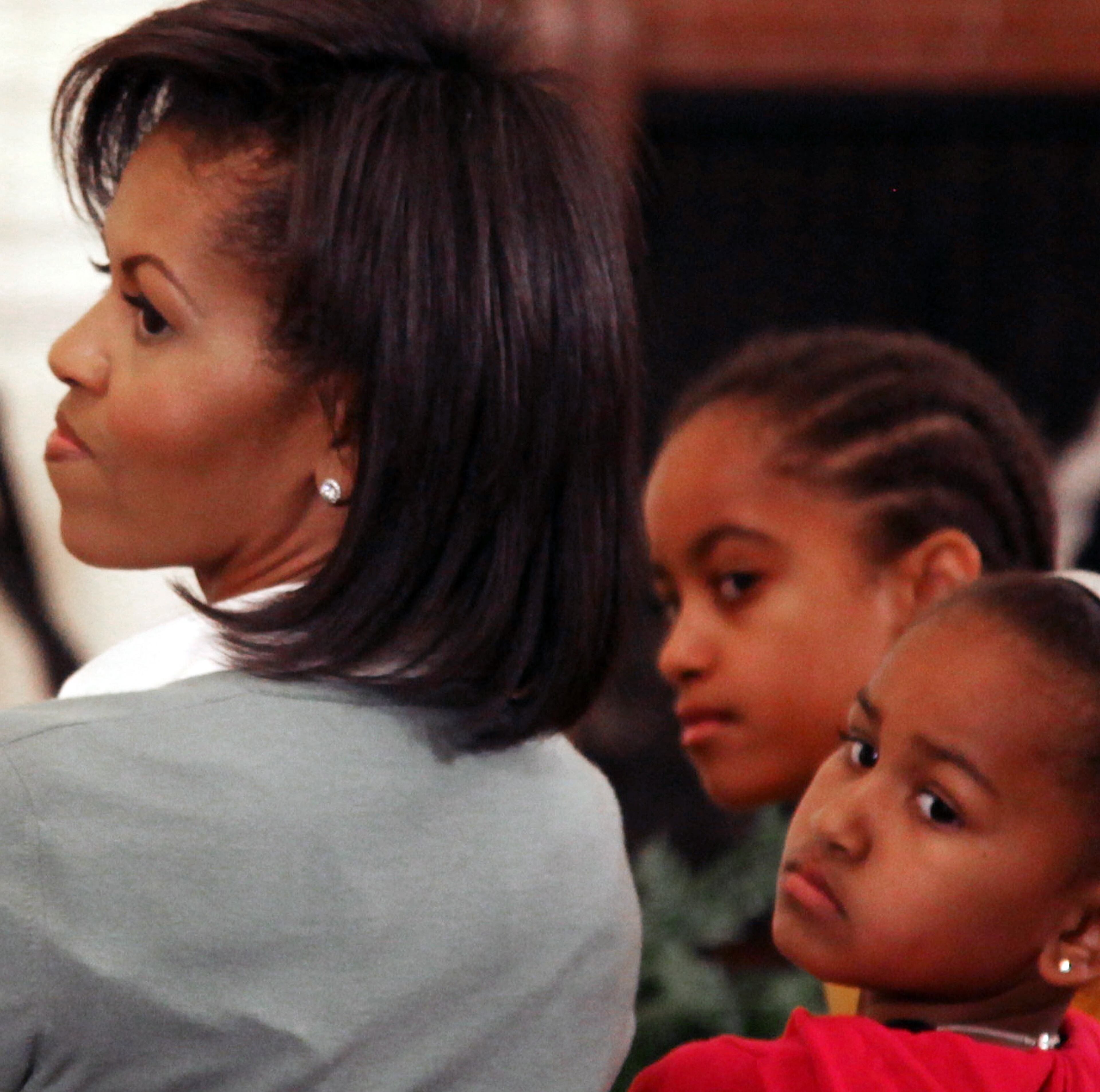 First Lady Michelle Obama (L), with daughters Malia Obama (C) and Sasha Obama (R) attend an event in the East Room of the White House on February 18, 2009 in Washington, DC. Mrs. Obama hosted an event honoring African American History Month by welcoming 6th and 7th grade DC school children to a performance at the White House. (Photo by Mark Wilson/Getty Images)
