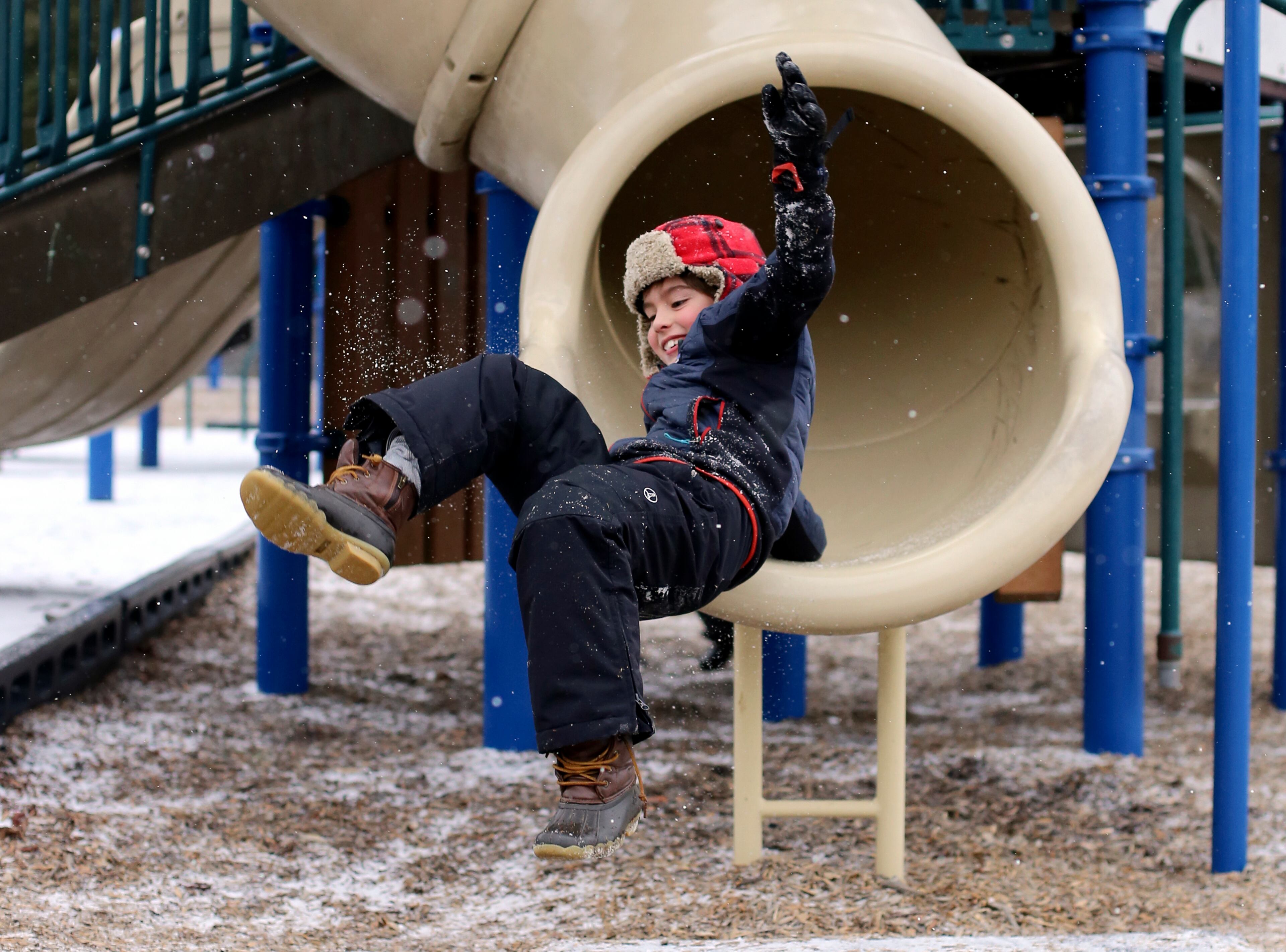 Seven-year-old Holden Royal catches air as he exits a slide at Riverview Park on Tuesday, Jan. 16, 2018 in Chattanooga, Tenn. Chattanooga experienced a light dusting of snow by late afternoon. The fear of inclement weather closed several area schools. (C.B. Schmelter/Chattanooga Times Free Press via AP)