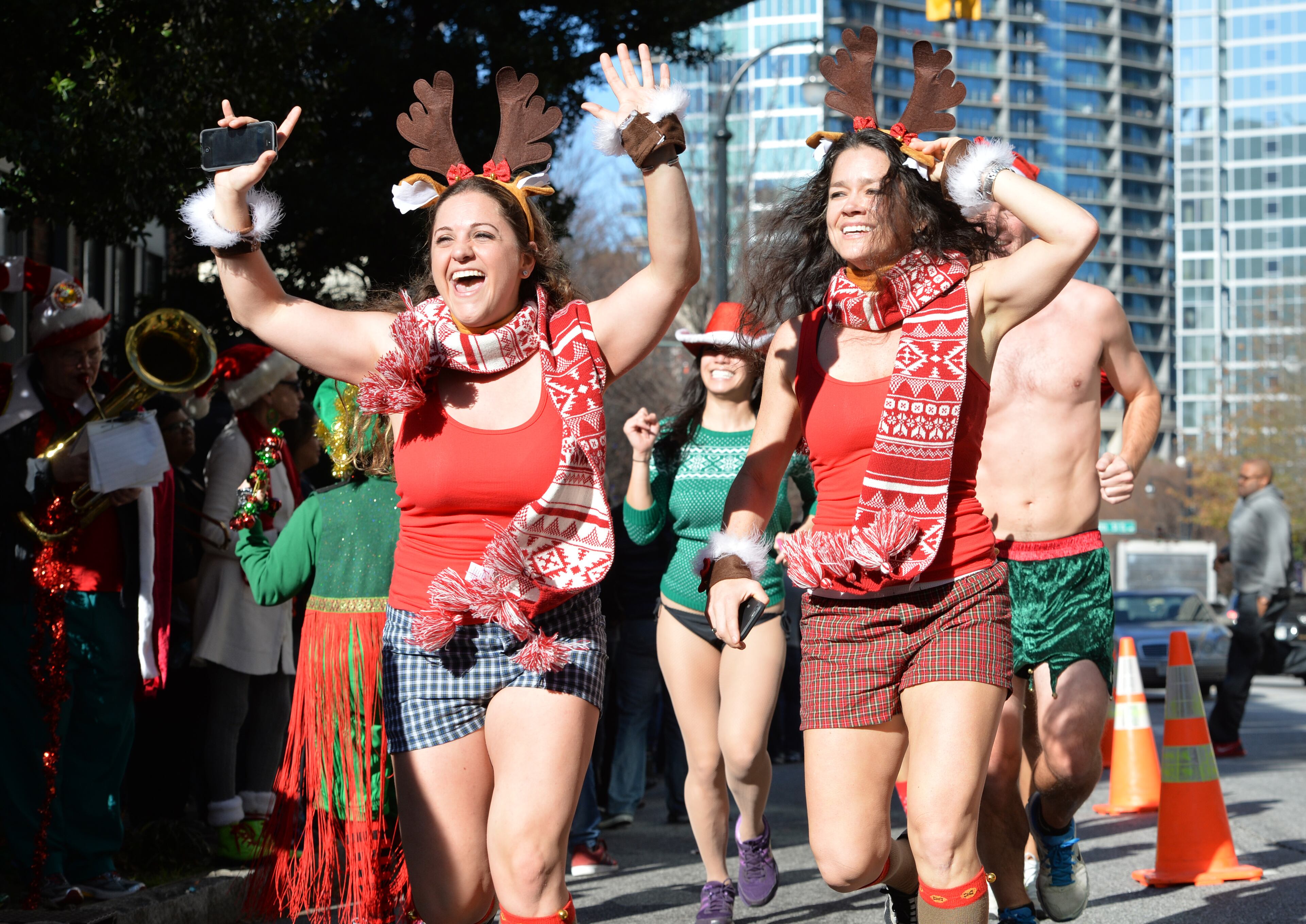 December 13, 2014 Atlanta - Runners approach the finish line near Hudson Grill Midtown on Peachtree Street during Atlanta Santa Speedo Run on Saturday, December 13, 2014. The race is run to raise money during the 2014 Santa Speedo Run. These 'lightly' dressed Santas are fundraising to support Everybody Wins! Atlanta, a nonprofit devoted to improving children's reading skills that below current grade level. HYOSUB SHIN / HSHIN@AJC.COM