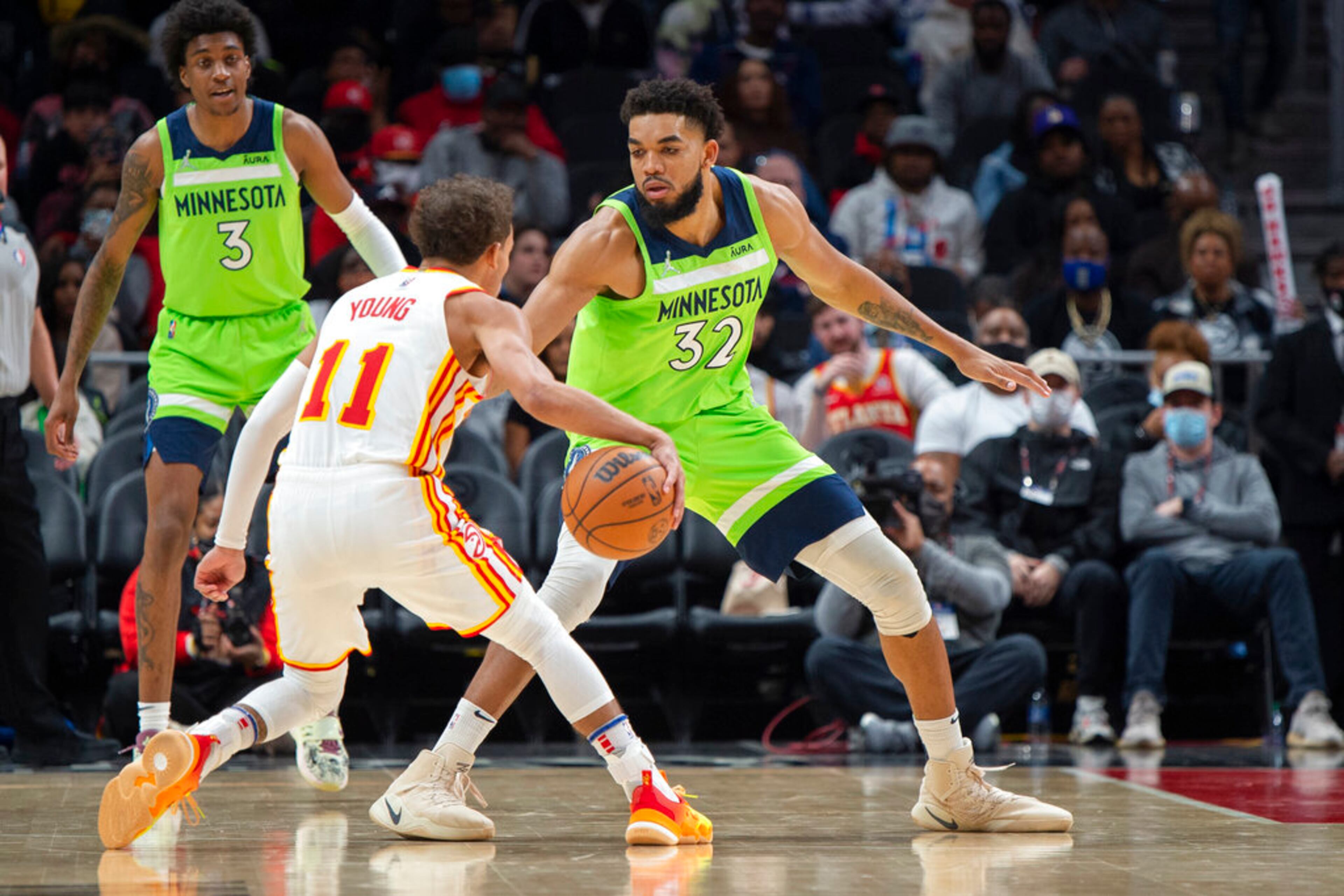 Atlanta Hawks guard Trae Young (11) dribbles the ball in front of Minnesota Timberwolves center Karl-Anthony Towns (32) during the second half of an NBA basketball game Wednesday, Jan. 19, 2022, in Atlanta. (AP Photo/Hakim Wright Sr.)