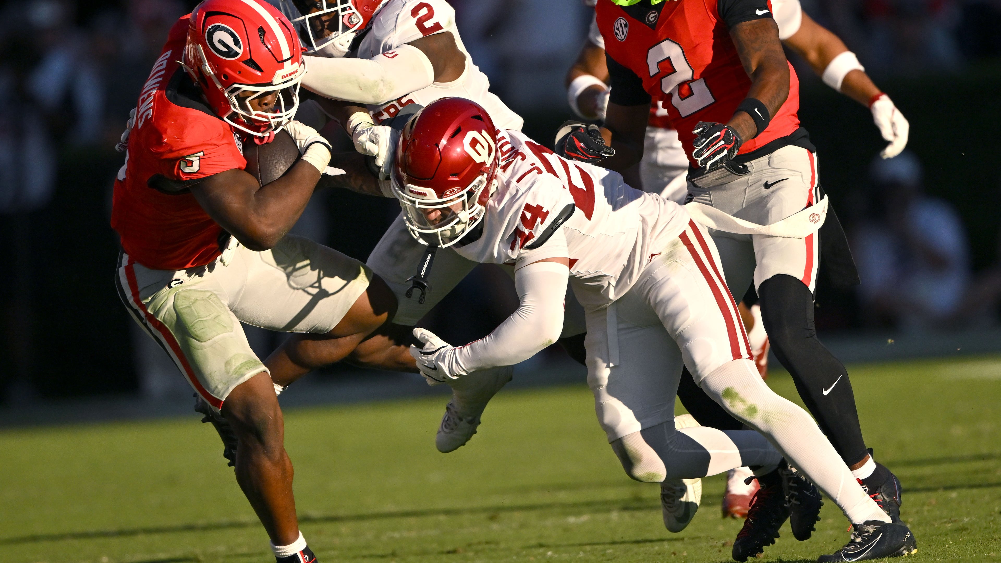 Georgia tailback Chauncey Bowens (left) tries to avoid a tackle by Oklahoma defensive backs Omarion Robinson and Jacobe Johnson on Saturday, Sept. 26, 2026, at Sanford Stadium in Athens. Bowens was added to the Bulldogs injury report late Wednesday night. (Hyosub Shin/AJC)