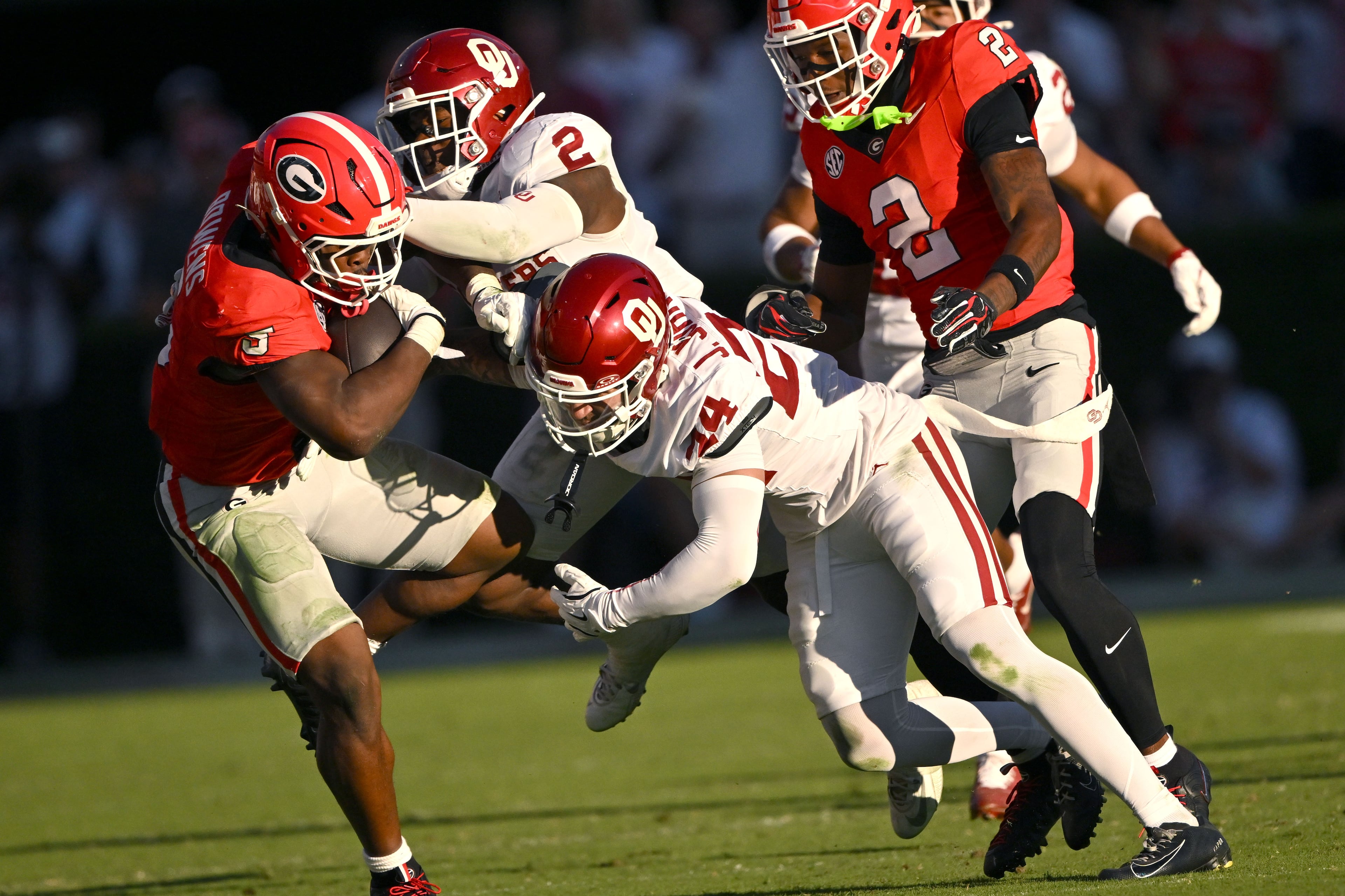 Georgia running back Chauncey Bowens (left) tries to avoid a tackle by Oklahoma defensive backs Omarion Robinson (second from left) and defensive back Jacobe Johnson (second from right) during the second half of an NCAA football game at Sanford Stadium on Saturday, Sept. 26, 2026, in Athens. Ga. Georgia defeated Oklahoma 41-13. (Hyosub Shin/AJC)