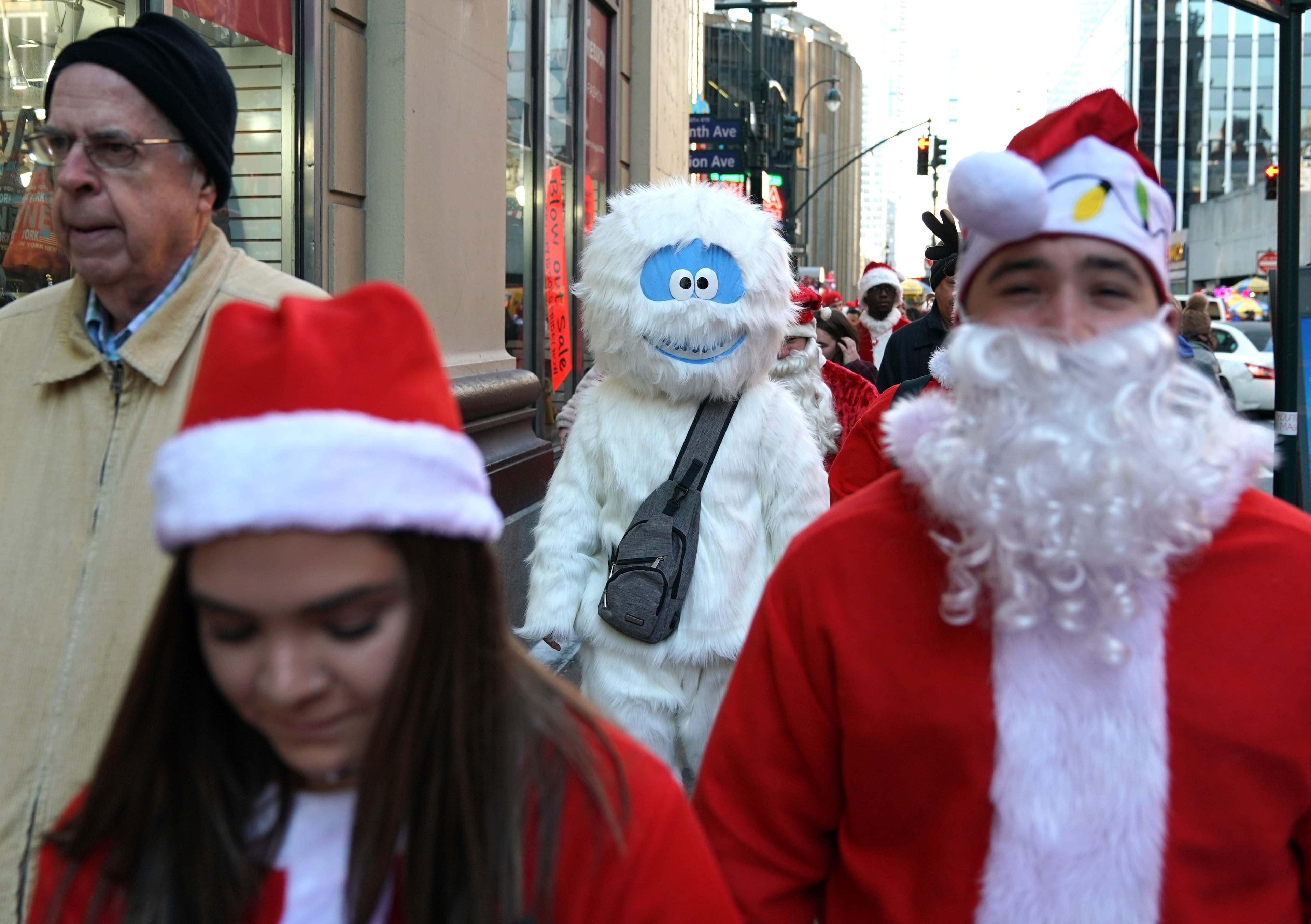 Revelers dressed as Santa Claus or in festive costumes arrive for the start of SantaCon 2018 in New York City December 8, 2018. - SantaCon the official Santa pub crawl happens in bars all across the world. (Photo by TIMOTHY A. CLARY / AFP)