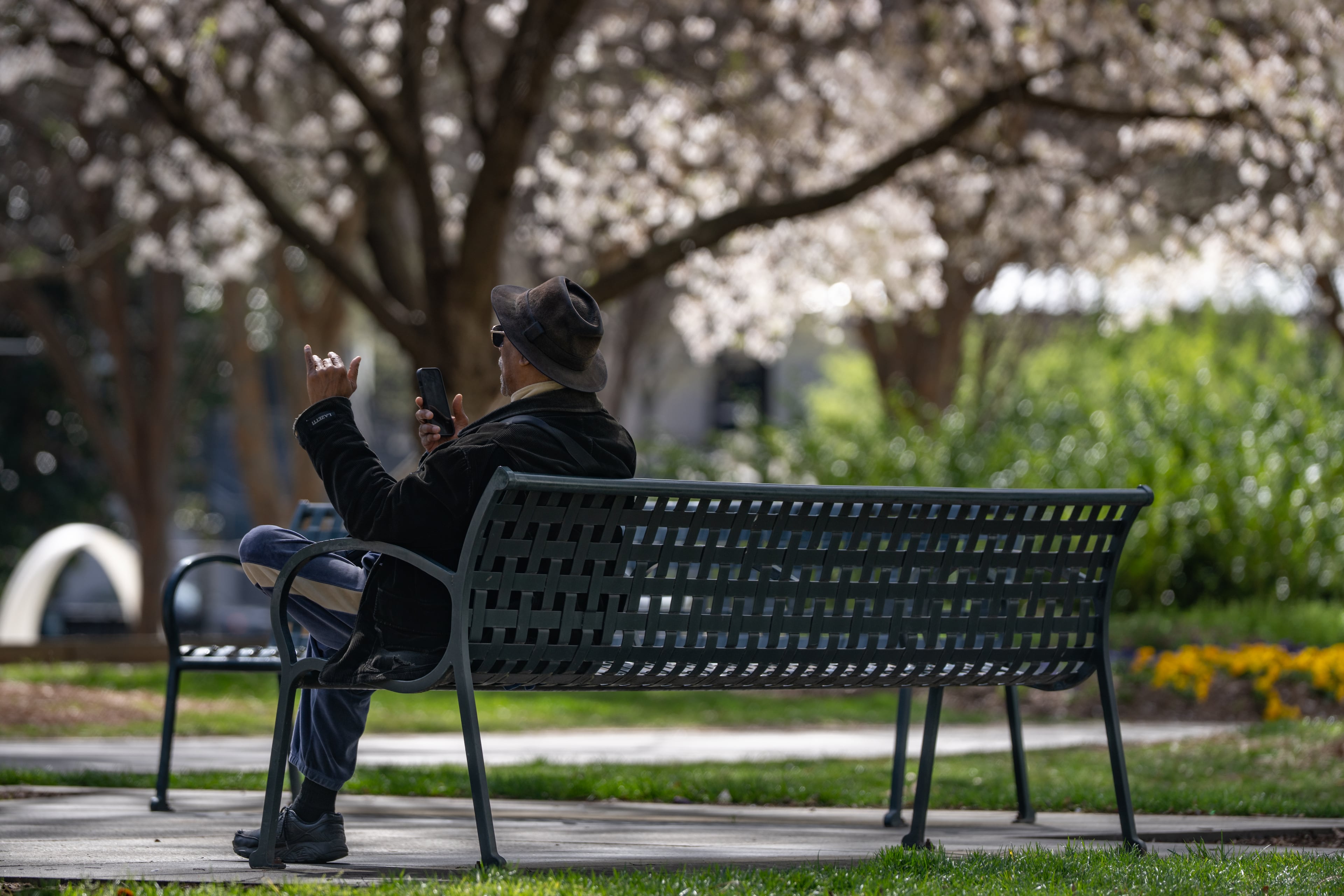A man sits on a bench outside of the Atlanta Federal Reserve Branch Building. Wednesday, March 19, 2025 (Ben Hendren for the Atlanta Journal-Constitution)