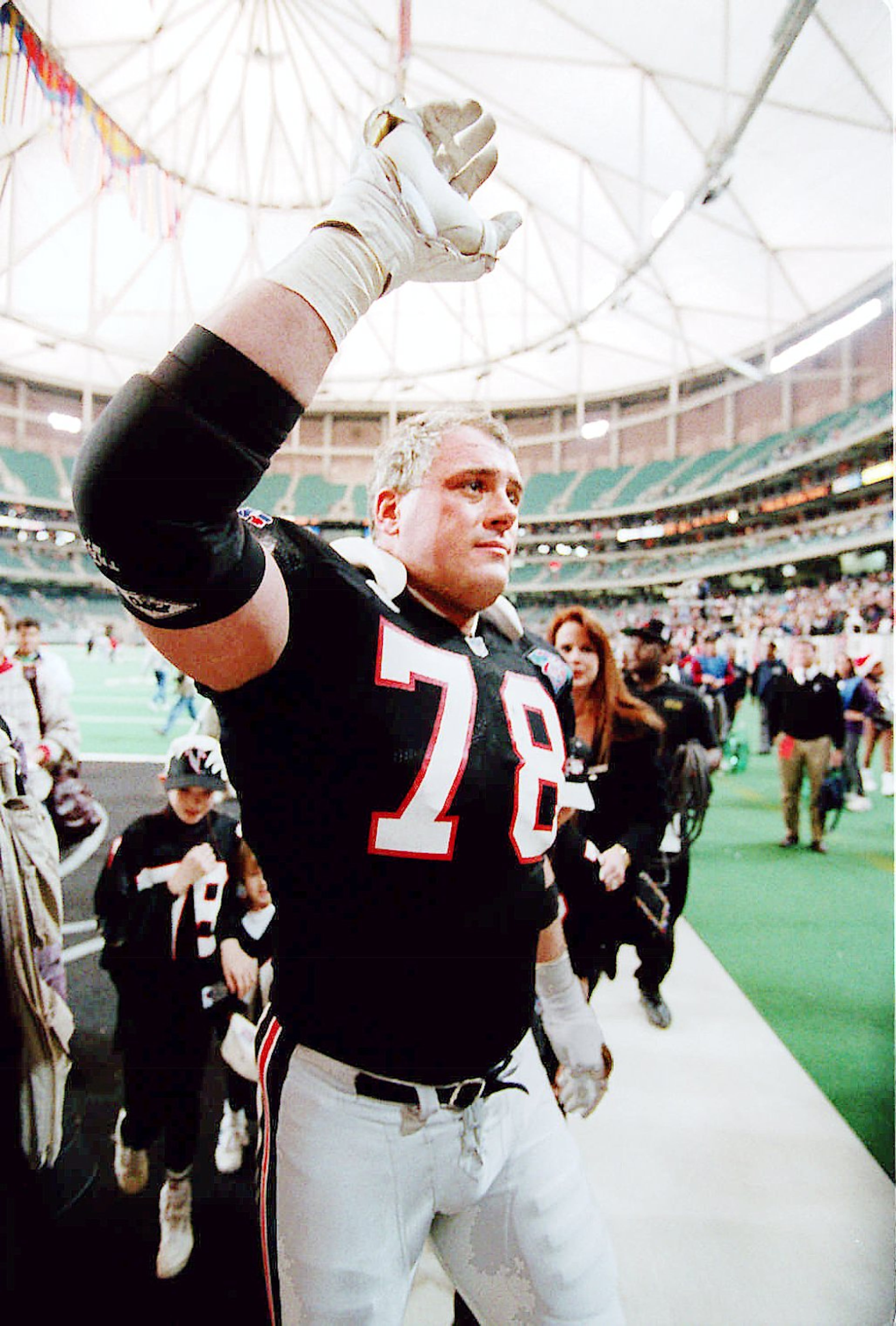 Falcons lineman Mike Kenn salutes the crowd as he walks off the field. AJC file photo