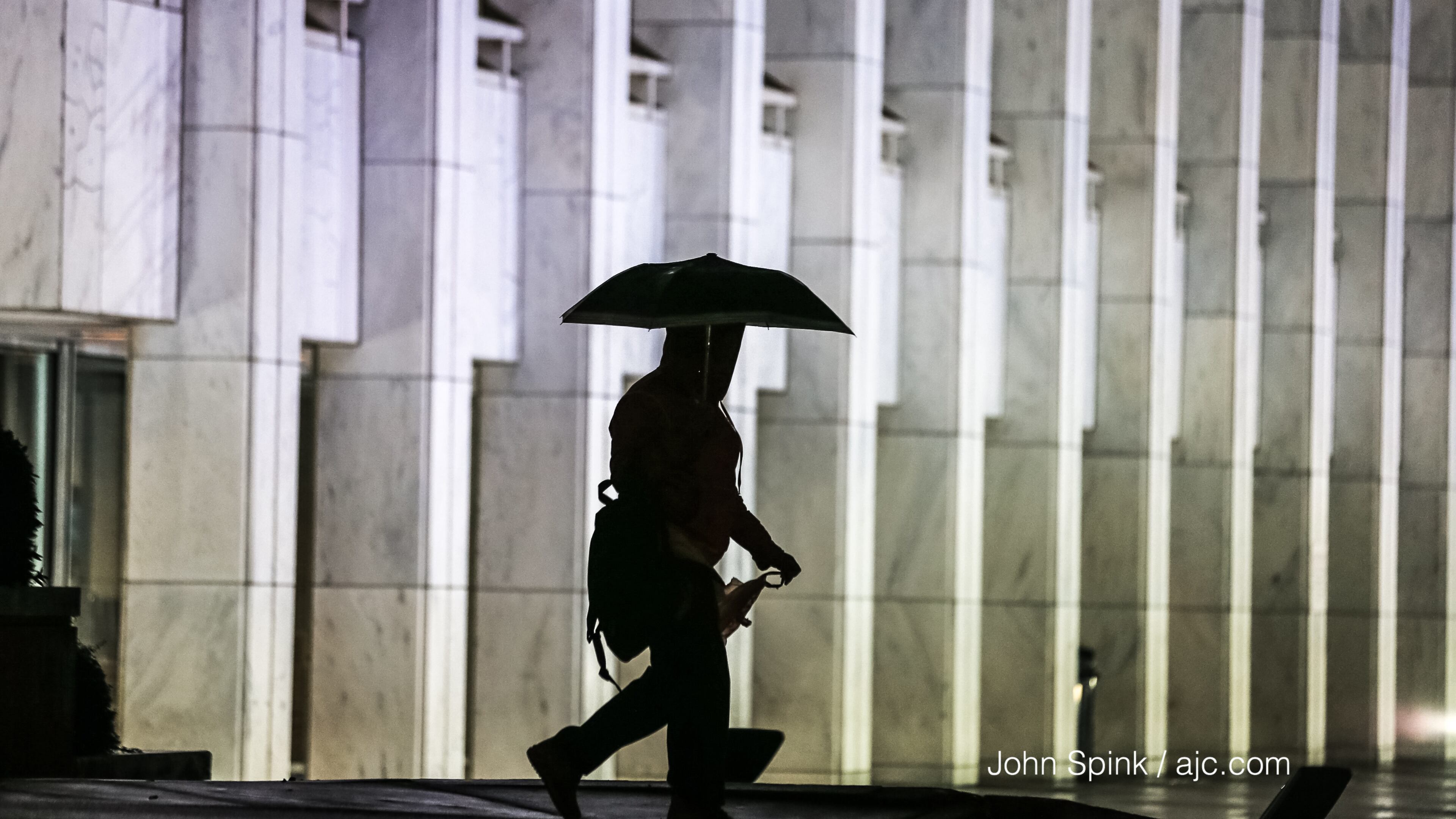 Shanell Rogers passes the Georgia Center on North Avenue at West Peachtree Street on a rainy Thursday morning.