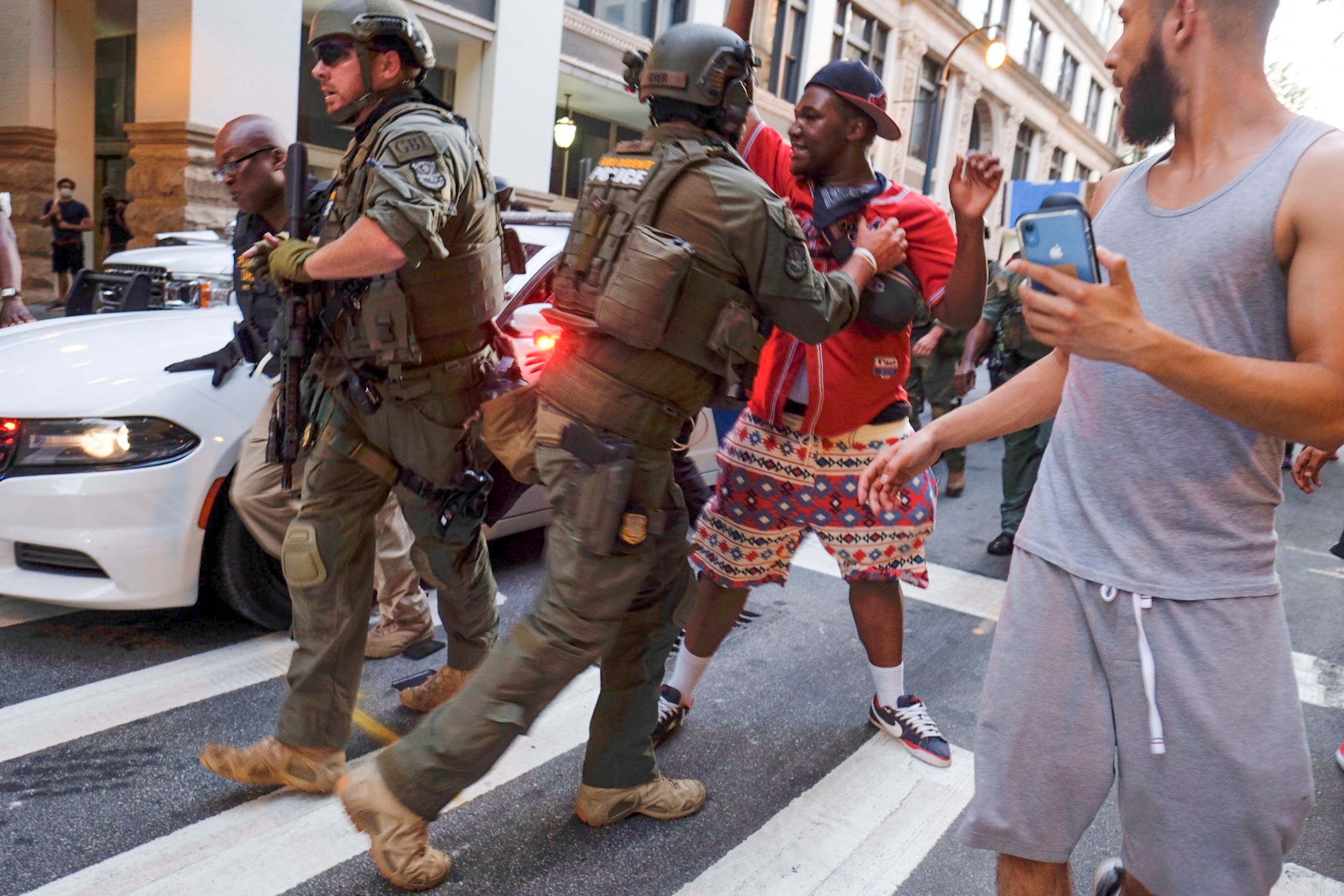 June 2, 2020 - Atlanta - Tense stand-off after homeland security officers took a protester into custody. They had to bring in a team of officers to extract the car. Could have been really bad, but the guy in yellow helped keep the crowd back a bit, and the officers did not escalate, even though they had to pull people out of the cars path Protestors in downtown Atlanta as protests continued for a fourth day. Protests over the death of George Floyd in Minneapolis police custody continued around the United States, as his case renewed anger about others involving African Americans, police and race relations. Ben Gray for the Atlanta Journal Constitution